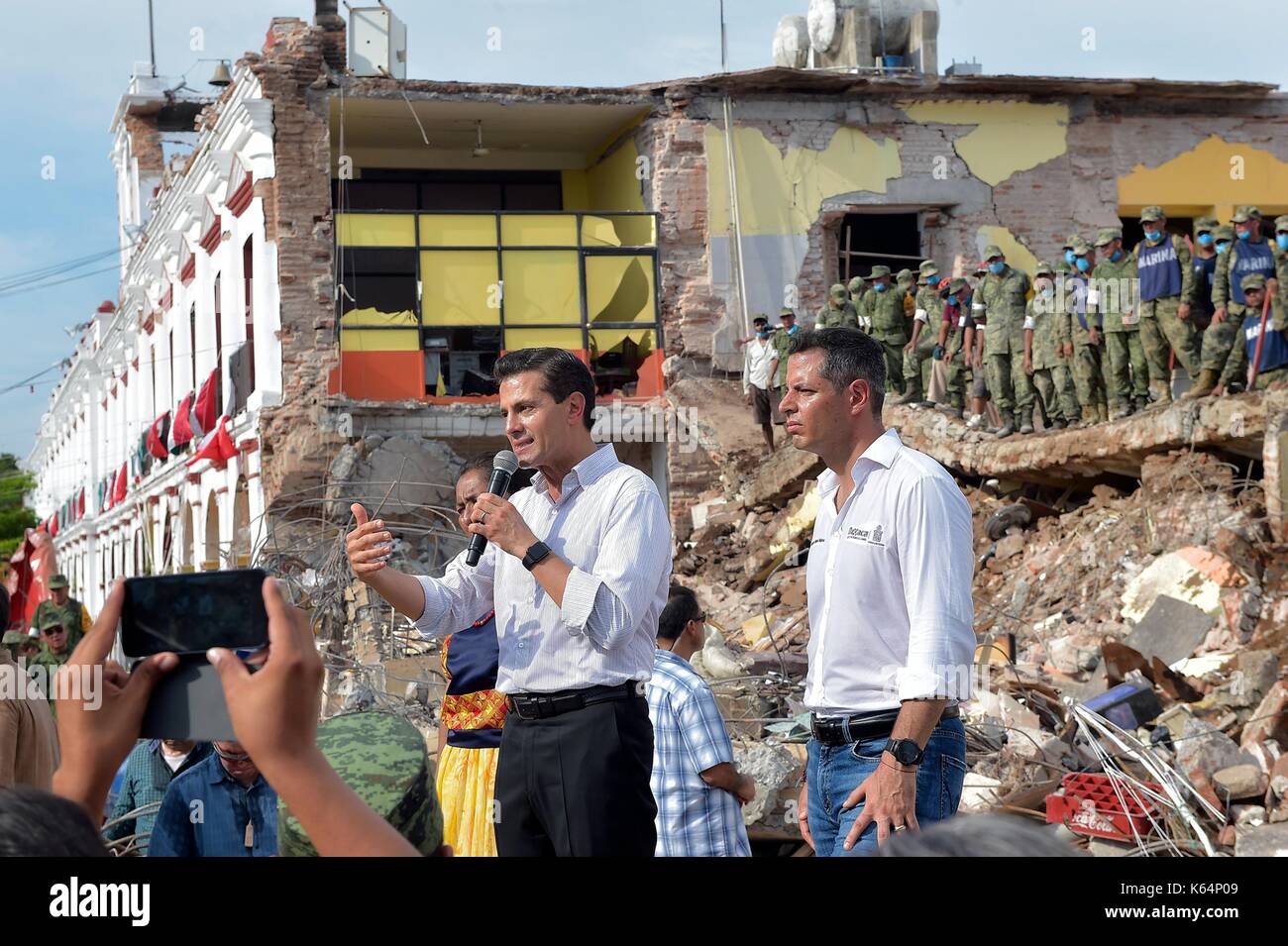 Der mexikanische Präsident Enrique Peña Nieto spricht für die Bewohner vor einer zerstörten Schule als er Erdbeben Schäden bei einem Besuch im Epizentrum der 9. September 2017 in Juchitán, Oaxaca, Mexiko nahe der Küstenstadt. Die massive 8.2 - Erdbeben schlug vor der südlichen Pazifikküste von Chiapas töten mindestens 60 Menschen und Nivellierung Bereiche in einigen südlichen Staaten. Stockfoto