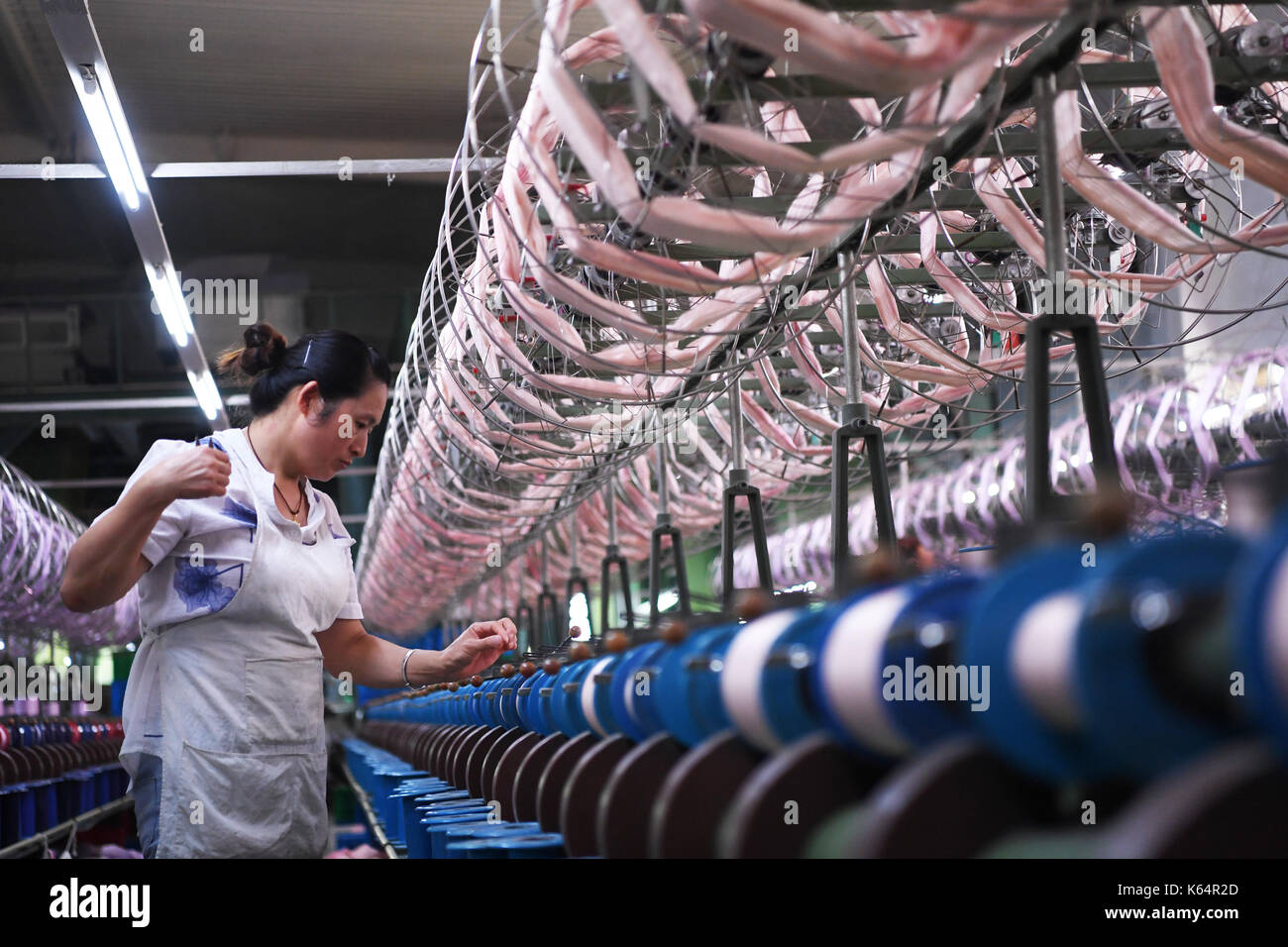 Nanchong, China's Sichuan Provinz. 11 Sep, 2017. Eine Frau arbeitet auf einer Textilproduktion in Sichuan EW Textile Co., Ltd. in Nanchong, Südwesten Chinas Provinz Sichuan, Sept. 11, 2017. Nanchong genossen Ruhm einer Stadt der Seide", die eine komplette Industrie, Mulberry - Deckt wachsende, silkworm, Seide, Seide Verarbeitung und Bildung und Forschung auf die seidenraupenzucht und die Seidenherstellung. Credit: Wang Quanchao/Xinhua/Alamy leben Nachrichten Stockfoto