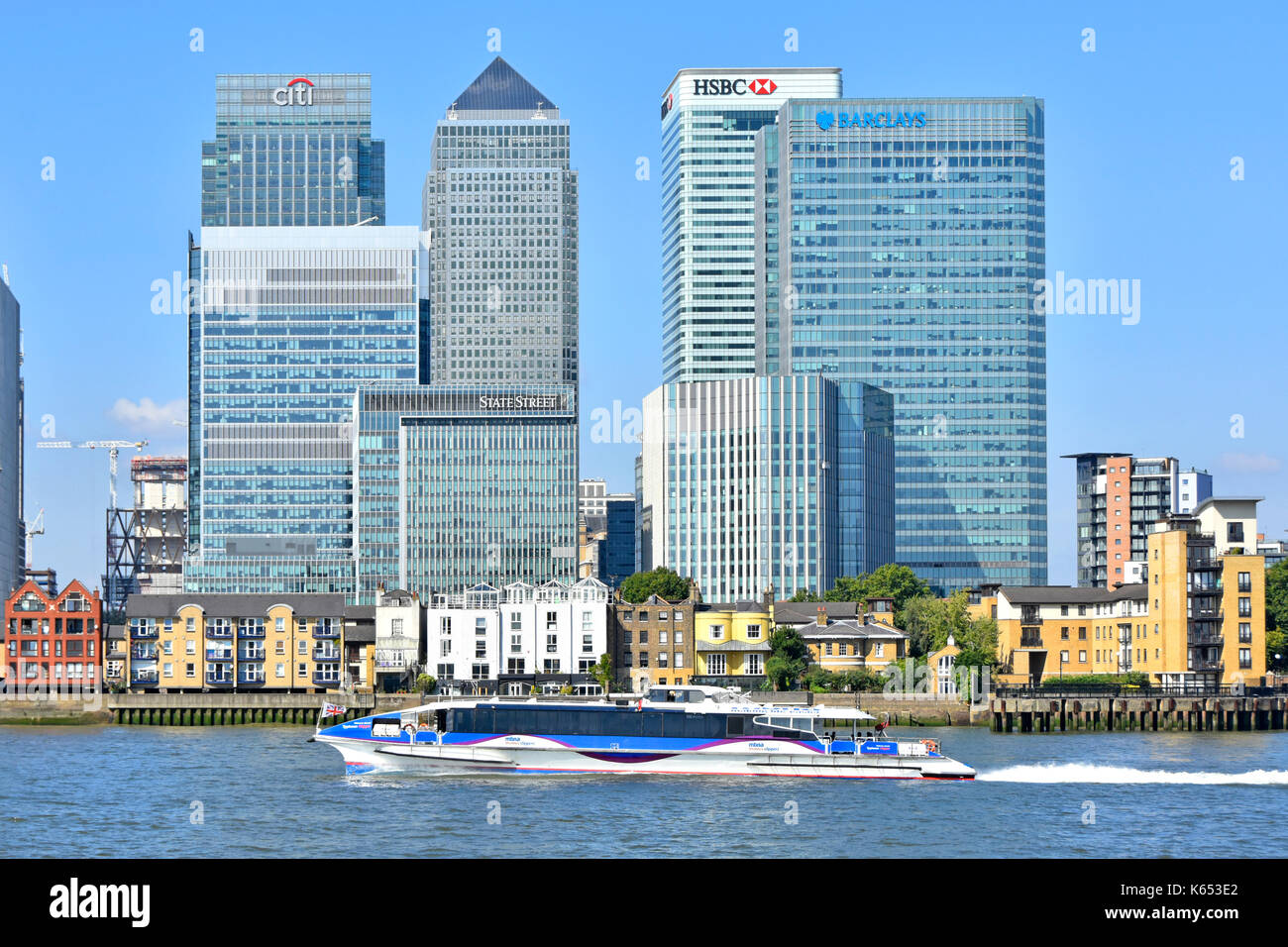 Themse & London Docklands Canary Wharf Skyline von modern Wahrzeichen Banken Wolkenkratzer Gebäude & Thames Clipper schnellen Flussbus Isle of Dogs Großbritannien Stockfoto