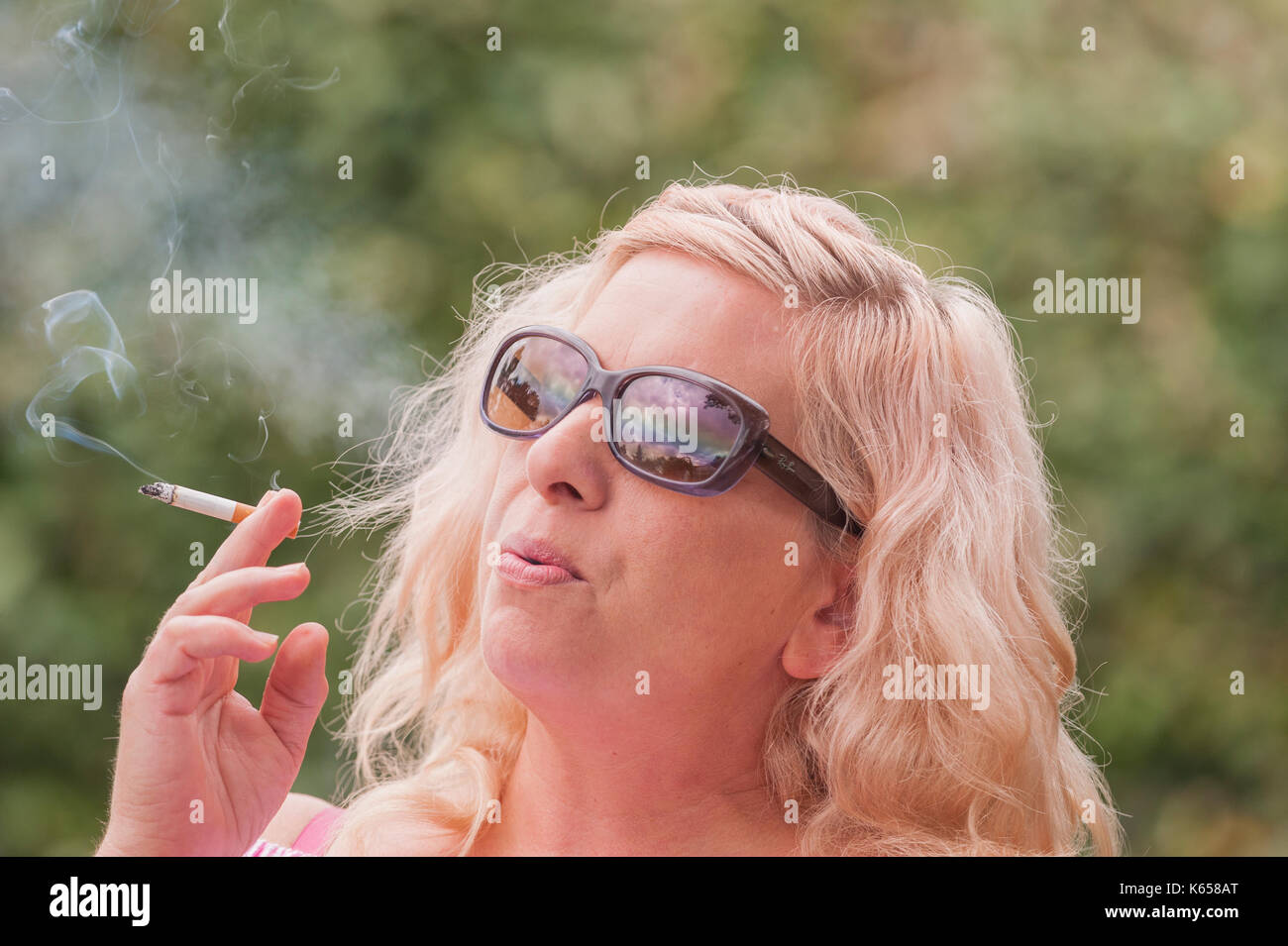 Ein MODEL RELEASED Frau in den 40er Jahren das Rauchen einer Zigarette im Freien in Großbritannien Stockfoto