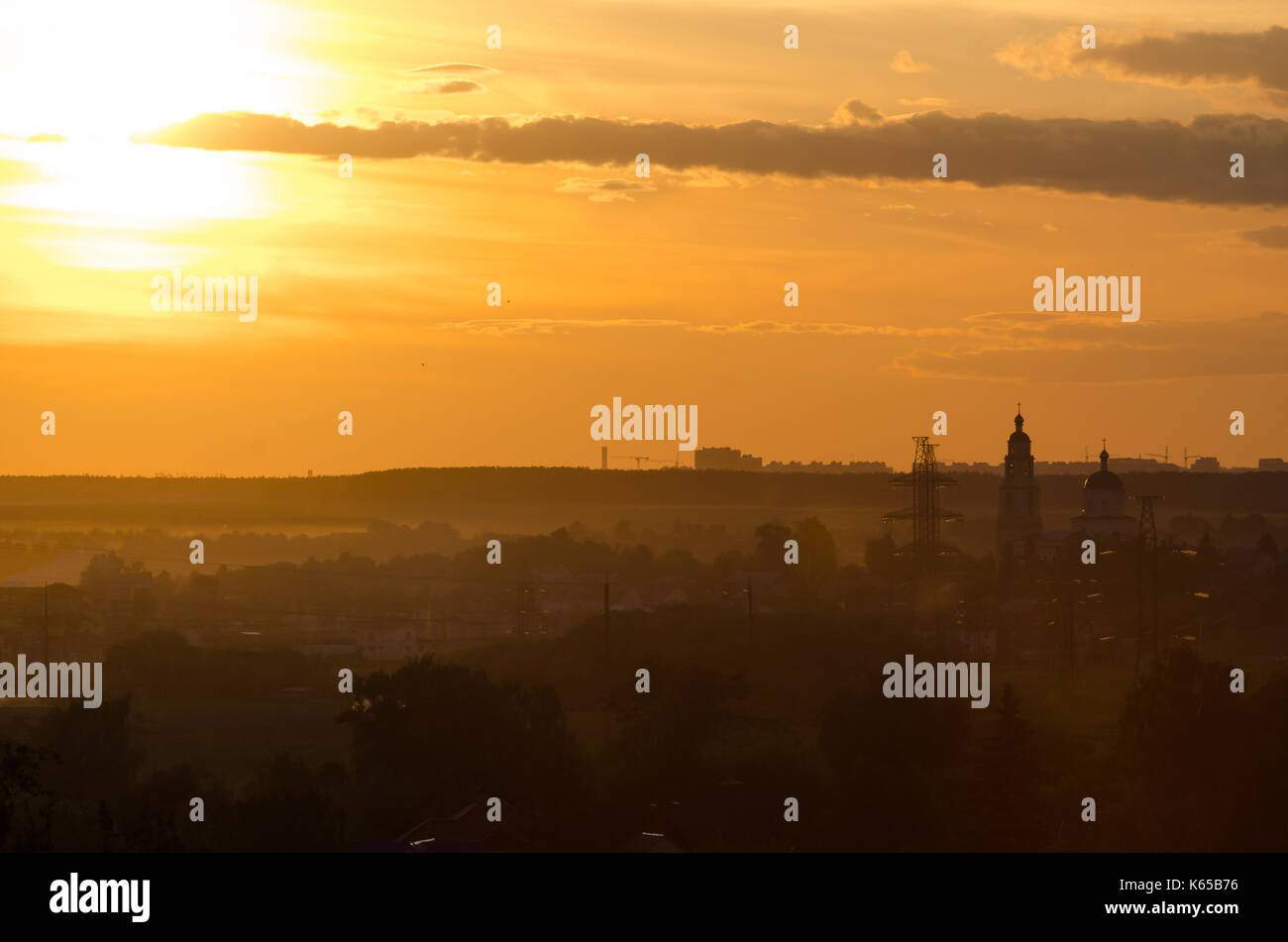 Schöne Aussicht auf den Sonnenuntergang. Ruhig Horizont und silhuette von Gebäuden weit entfernt. Sun geht hinter dem Horizont Stockfoto