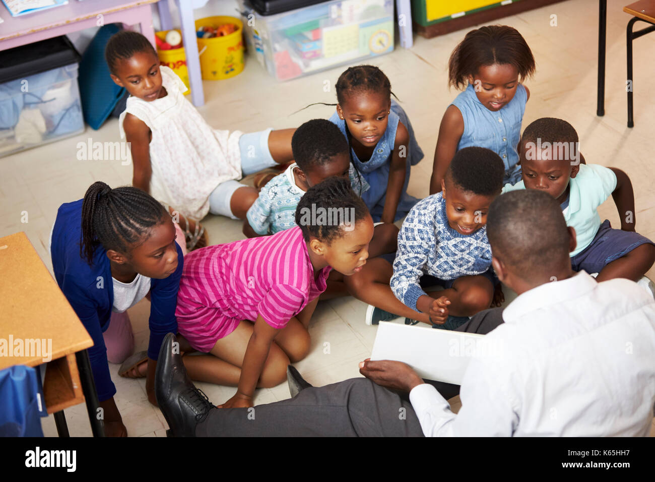 Lehrer lesen Kinder ein Buch in einer Grundschule Lektion Stockfoto