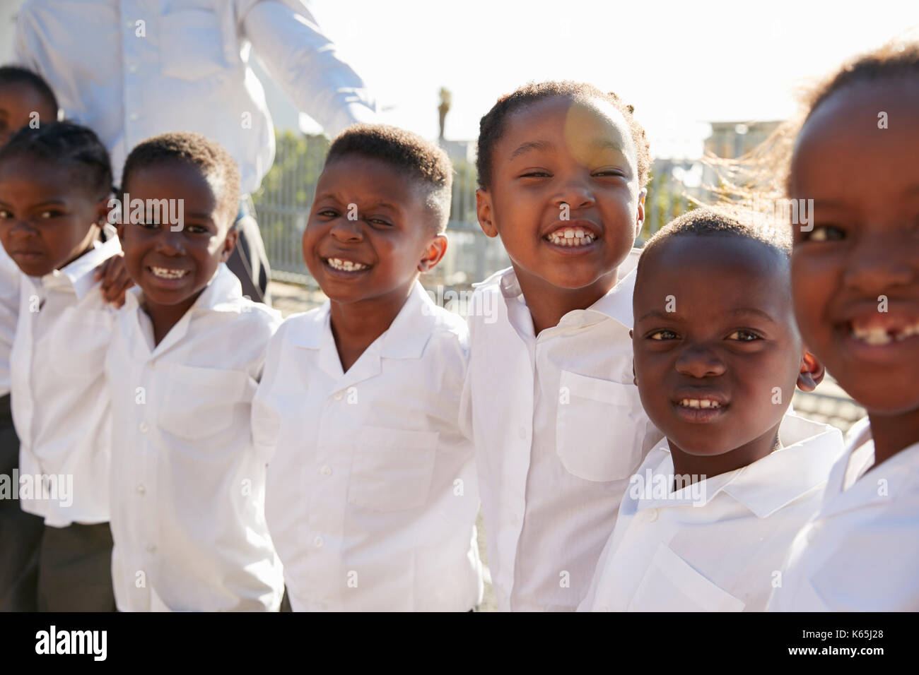 Grundschule Kinder lächeln in die Kamera in Spielplatz Stockfoto