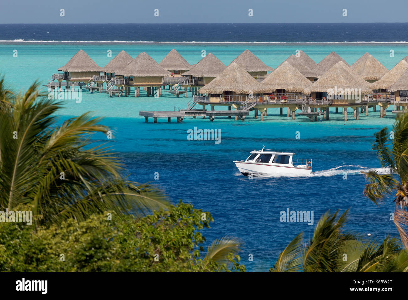 Motorboot, Bungalows im türkisfarbenen Meer, Resort Sofitel Bora Bora, Insel Bora Bora, Gesellschaftsinseln, Französisch Polynesien Stockfoto