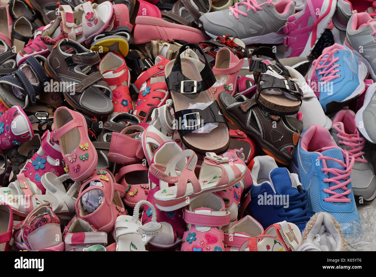 Kinder Schuhe zum Verkauf an. Sortierte Stapel der Schuhe. Stockfoto