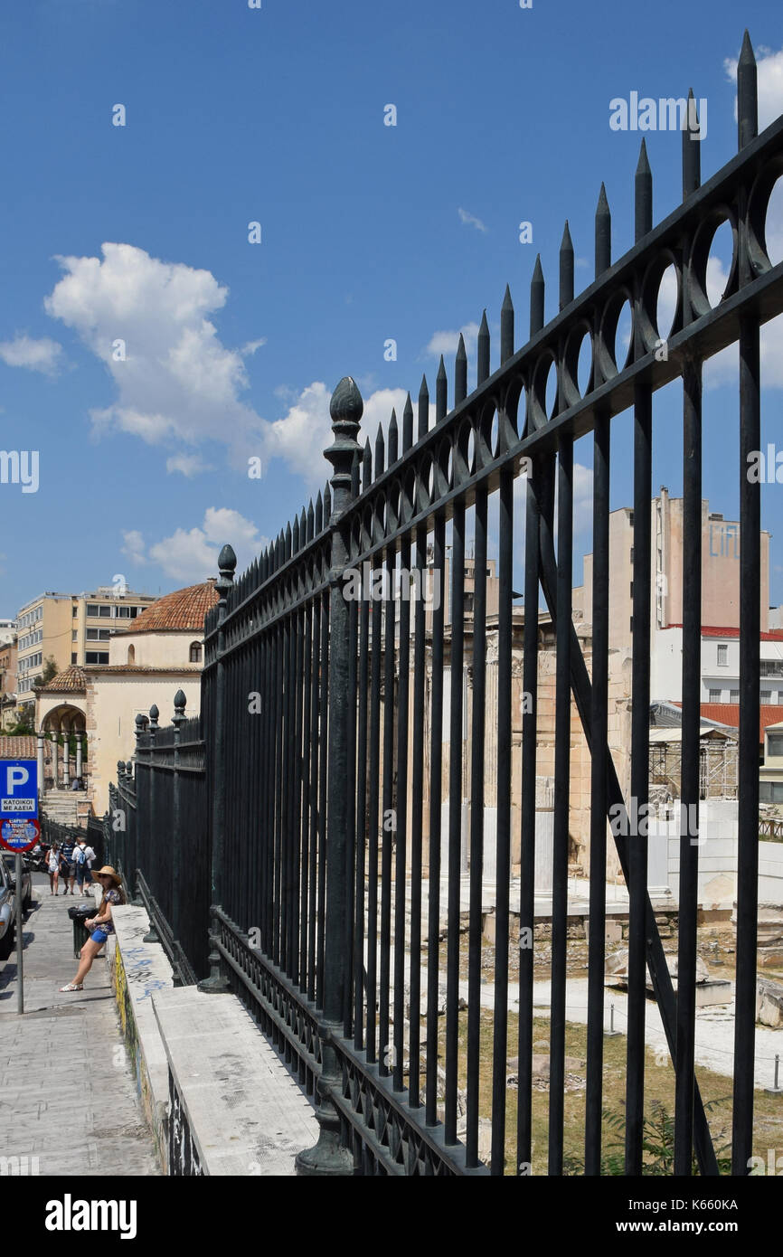 Athen, Griechenland - 12. JUNI 2015: Menschen gegen Metall Zaun an archäologische Stätte ruhen. Straße in der Innenstadt von Athen, Griechenland. Stockfoto