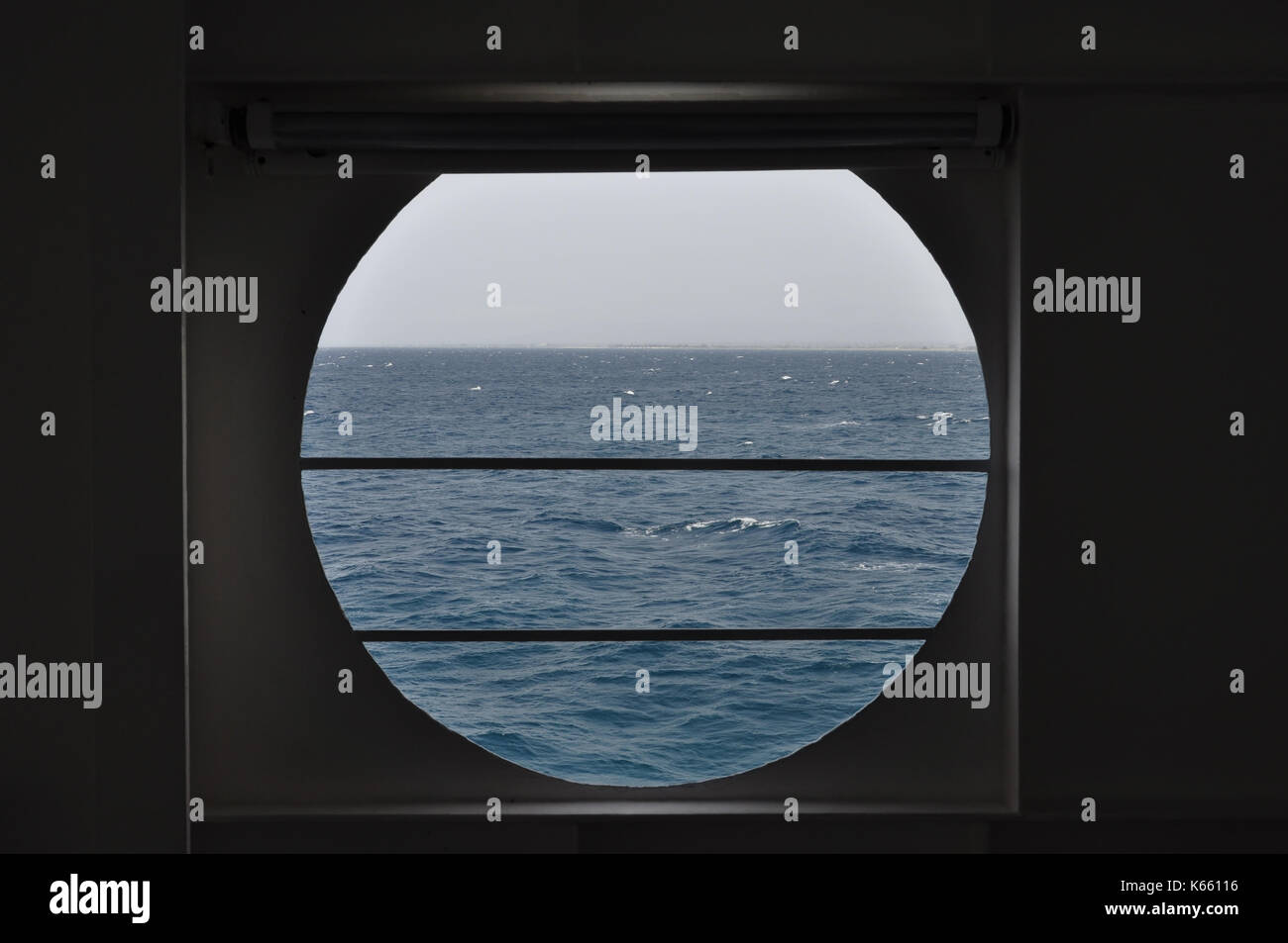 Schiffs Bullauge mit Blick auf das Meer und den Horizont zu öffnen. Zusammenfassung Hintergrund. Stockfoto