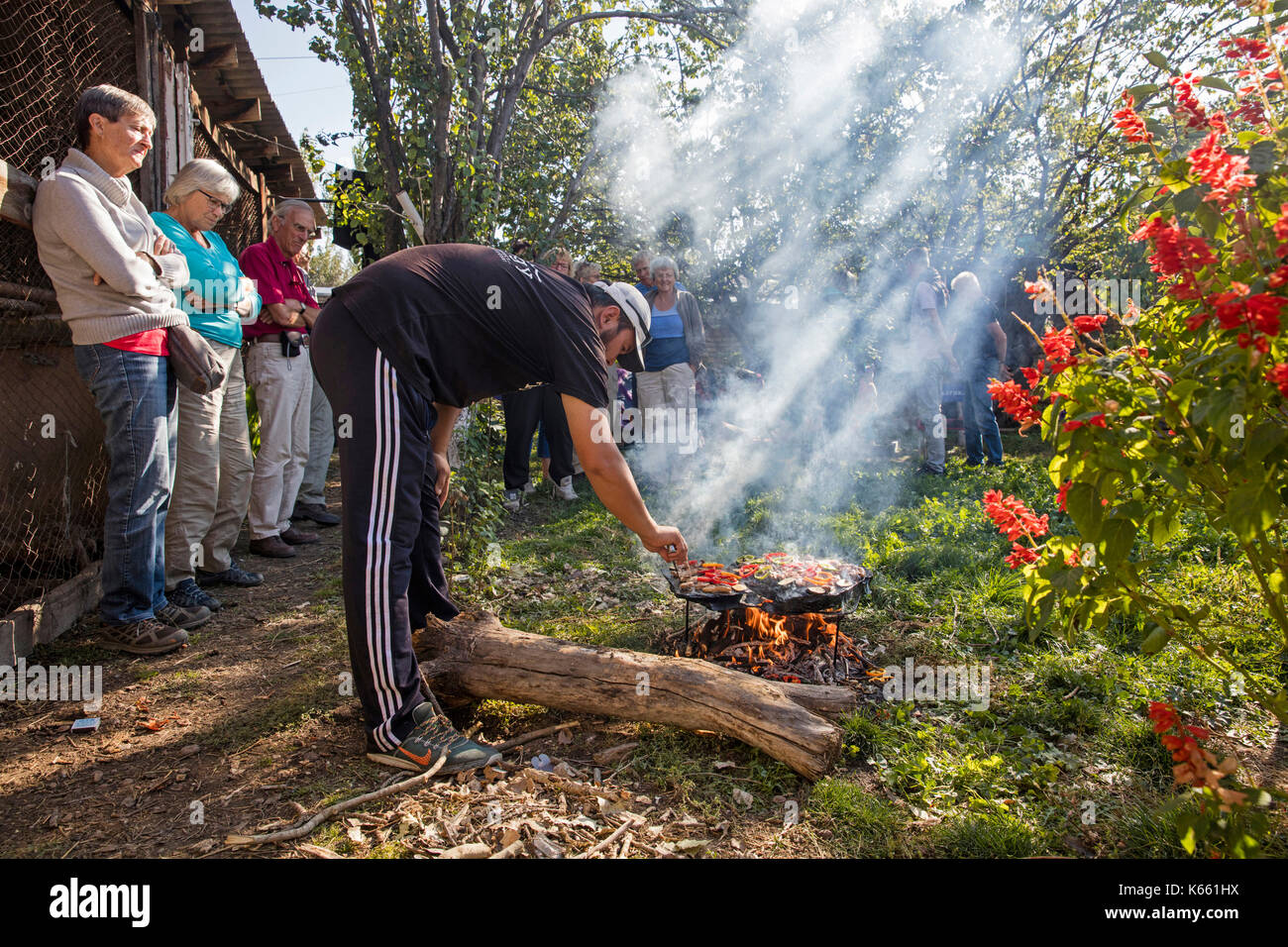 Kirgisische mann Kochen für Touristen auf einer traditionellen Stein Grill in Kirgisistan Stockfoto