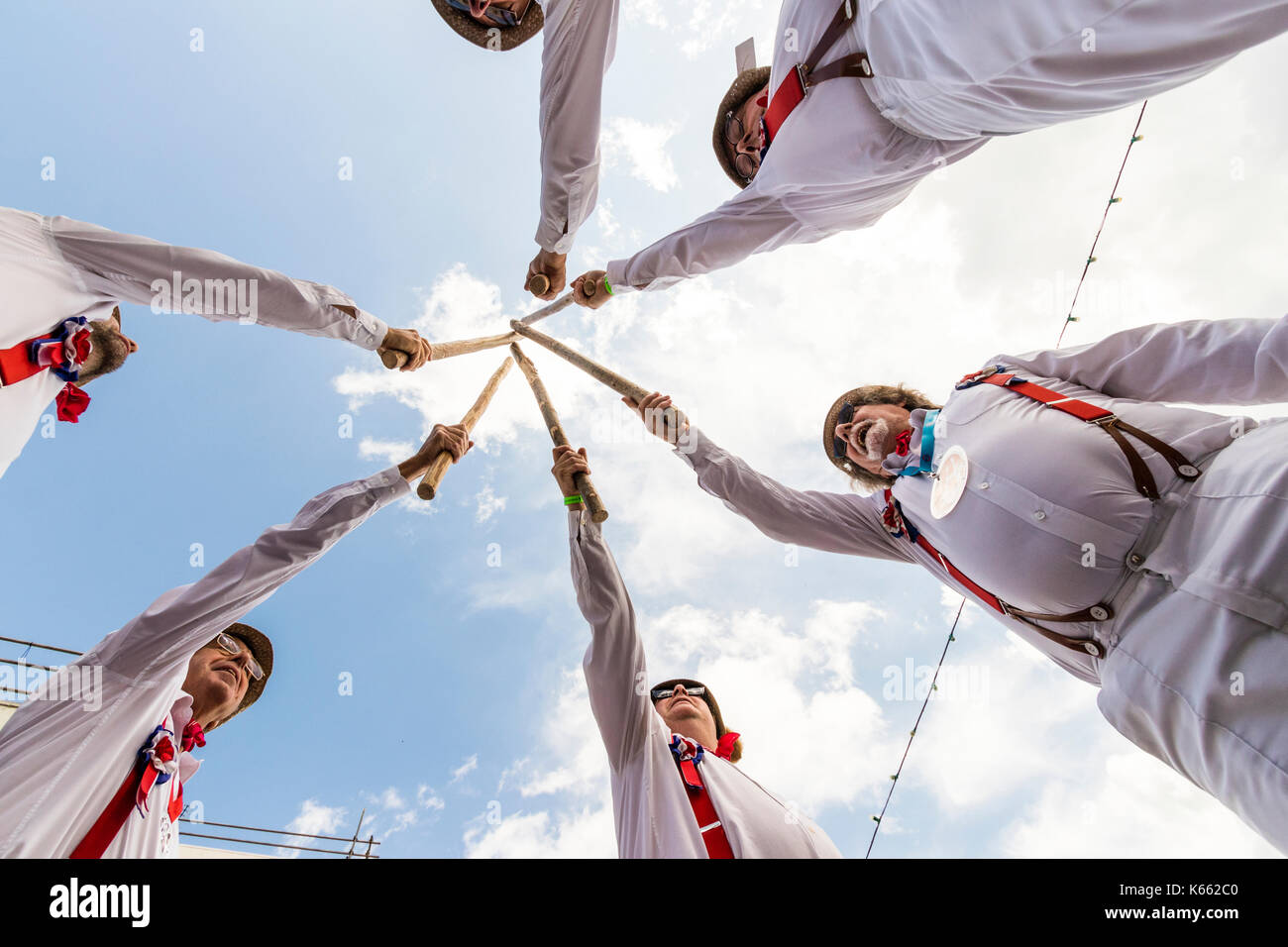 Englisch Hartley traditionelle Morris Men Team im Kreis holding Holzpfähle zusammen. Vom Boden bis zum Himmel schauen gesehen, Männer hoch über dem Betrachter. Stockfoto