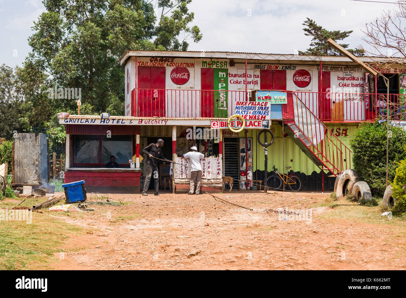 Am Straßenrand kleine Hotel und Metzgerei mit Menschen außerhalb, Kenia Stockfoto