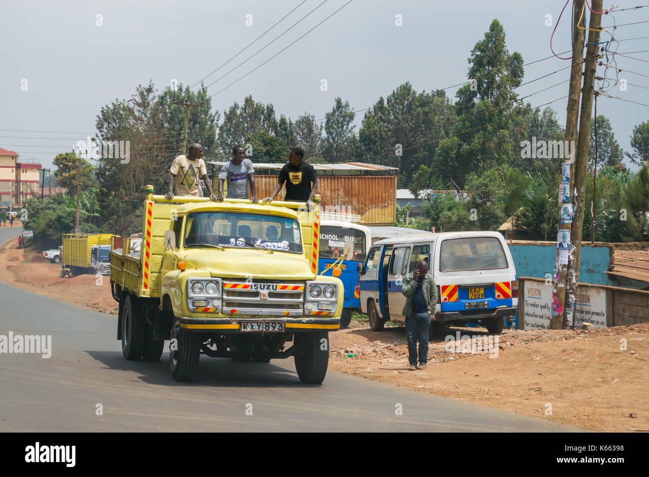Drei stehende Männer während der Fahrt auf der Rückseite des offenen Lkw, Kenia Stockfoto