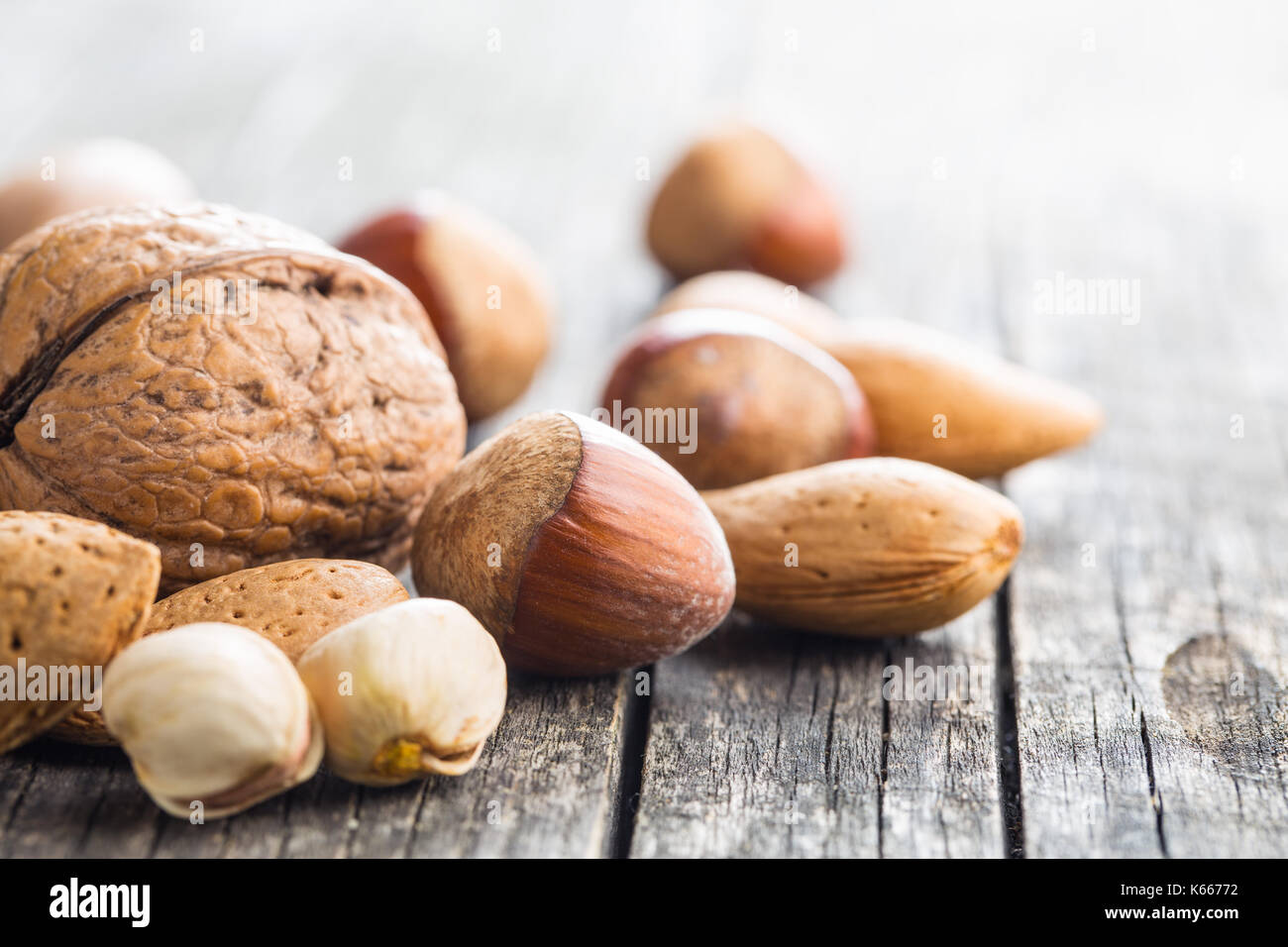 Verschiedene Arten von Muttern in der nußschale. Haselnüsse, Walnüsse, Mandeln, Pecan Nüsse und Pistazien auf alten Holztisch. Stockfoto