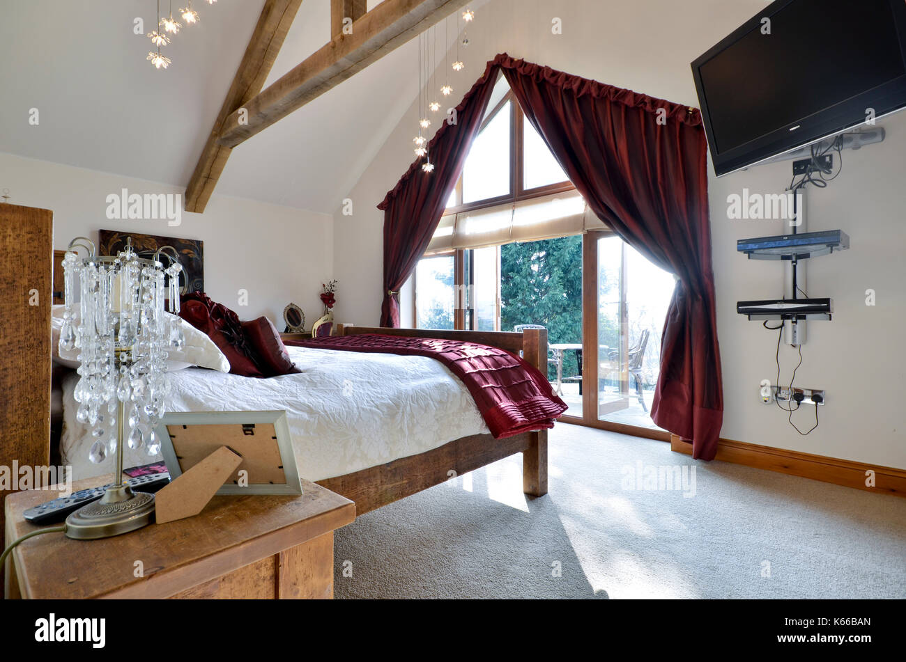Luxuriöse Schlafzimmer mit großen Terrassentüren Stockfoto