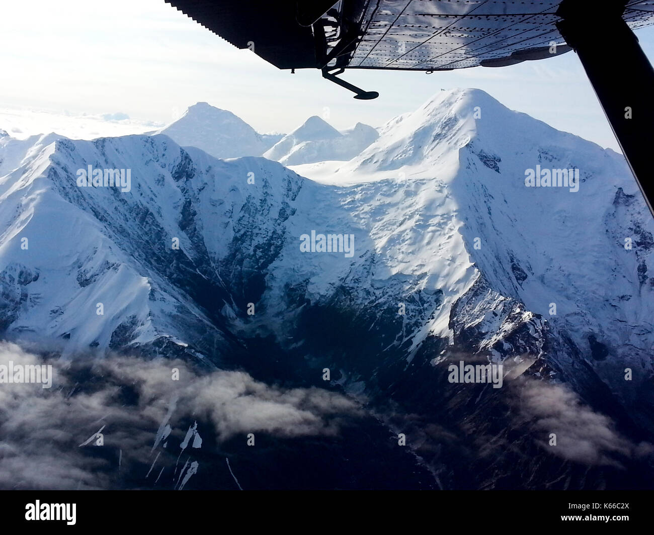 Antenne AUS DER ANSICHT TOURING Flugzeug auf die schneebedeckten Berge und an der Unterseite der Tragfläche, ALASKA Stockfoto