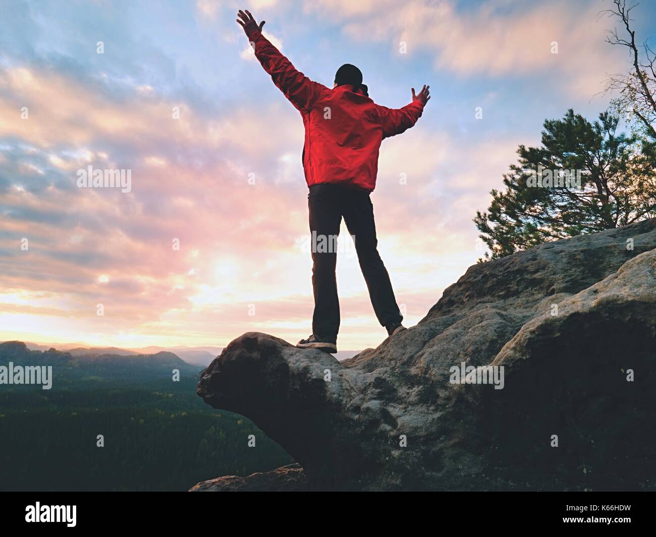 Fühlen Sie sich frei. Glücklicher Mann Geste des Triumphes mit Widdern in der Luft. Lustige Wanderer auf der Spitze des Sandsteinfelsen im Nationalpark Sachsen Schweiz beobachten horiz Stockfoto