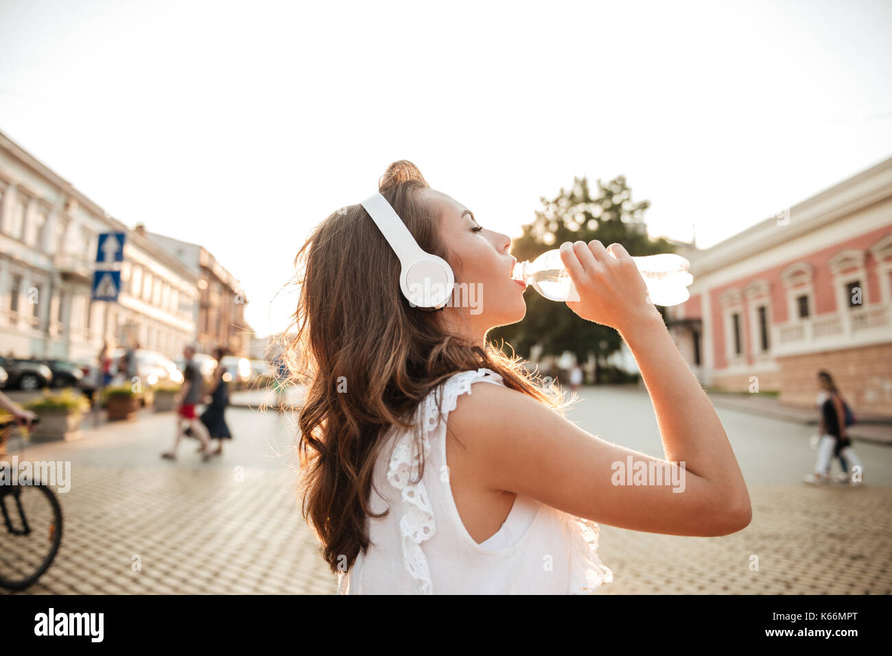 Bild von erstaunlich junge Frau im Freien. Neben der Suche Musik Trinkwasser. Stockfoto