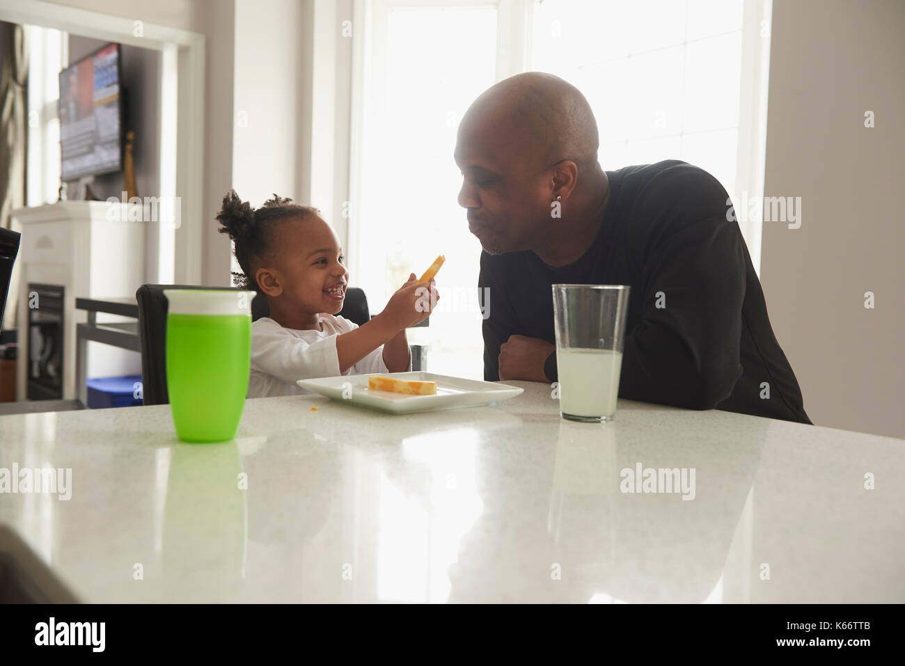 Schwarze Tochter mit Speisen zu Vater Stockfoto
