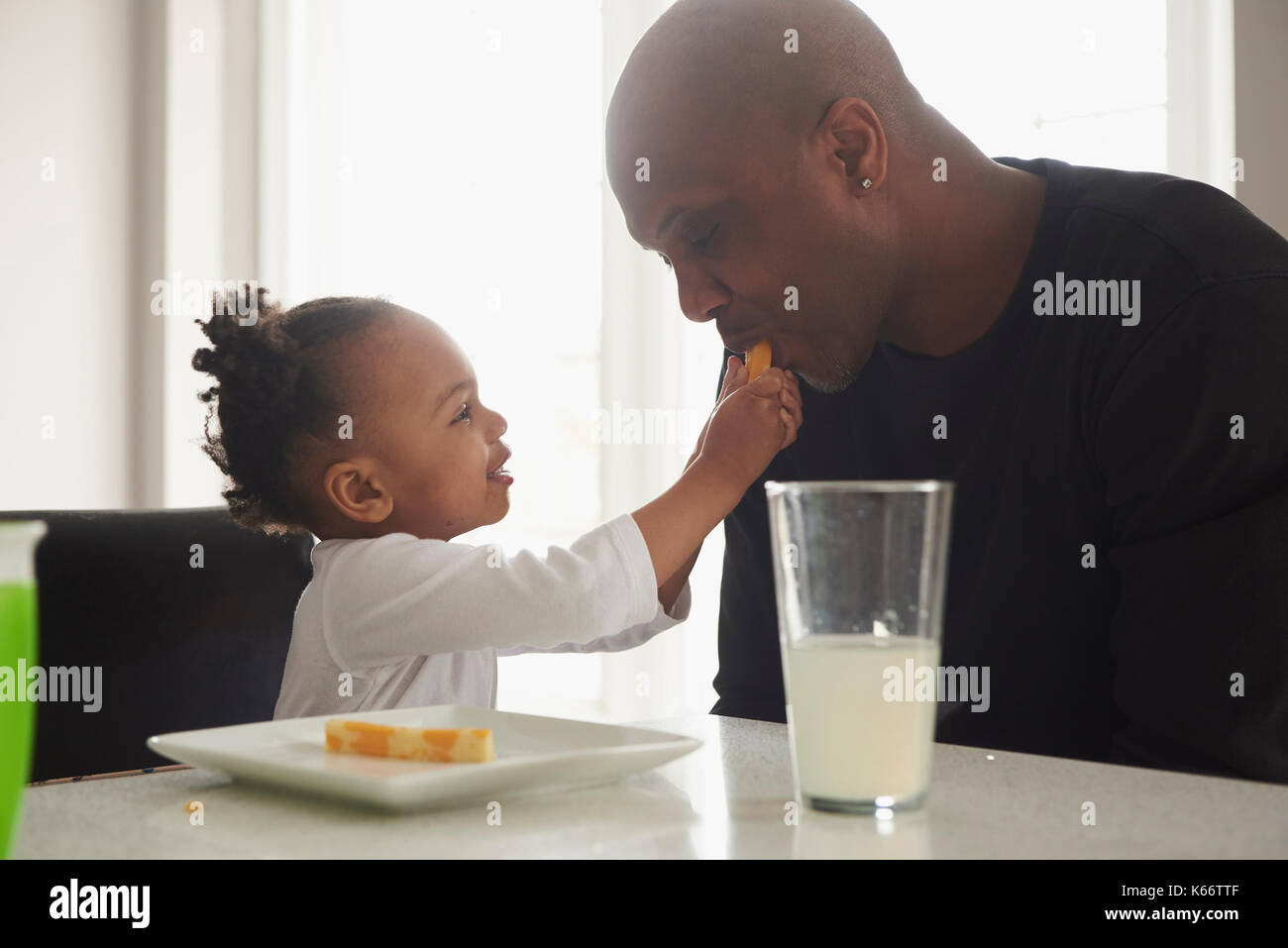 Schwarze Tochter Fütterung essen Vater Stockfoto