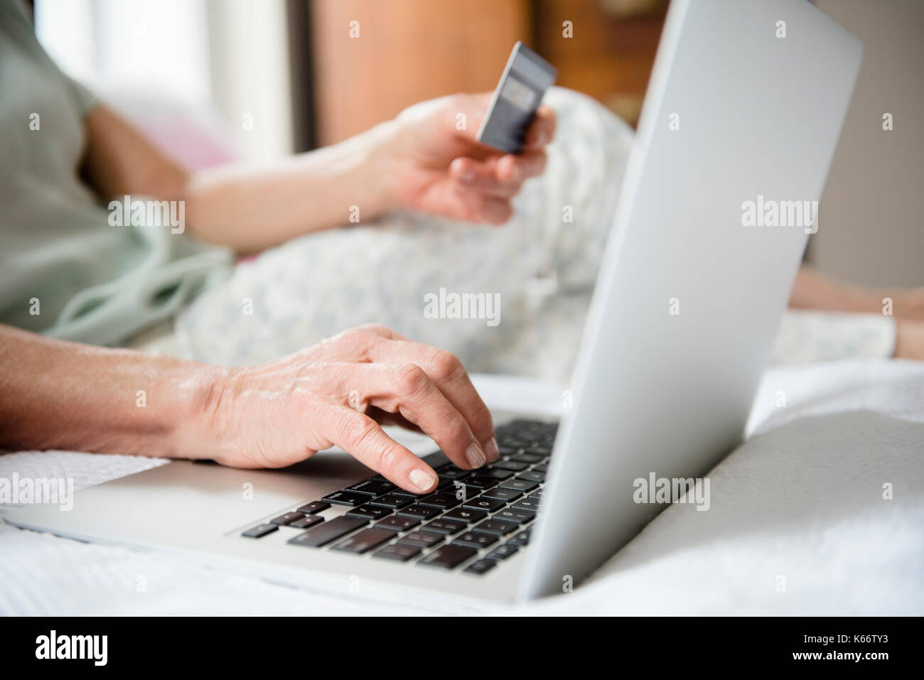 Hände der älteren Frau Shopping Online mit Kreditkarte und Laptop Stockfoto