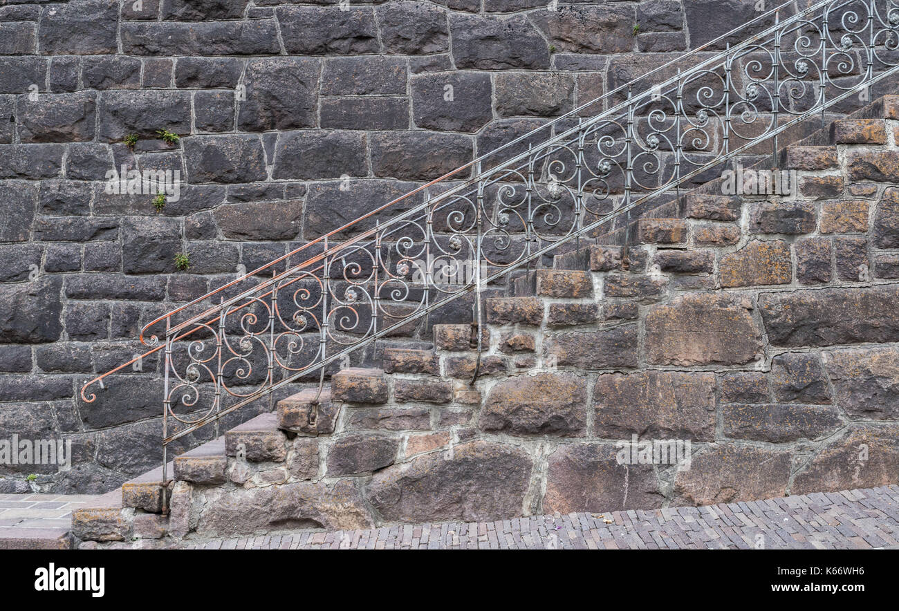 Alte Treppe gegen einen Felsen Fassade Stockfoto