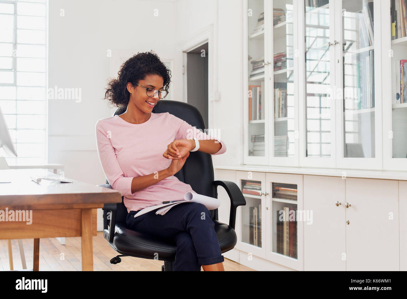 Gemischte Rasse Frau Kontrolle Armbanduhr Stockfoto
