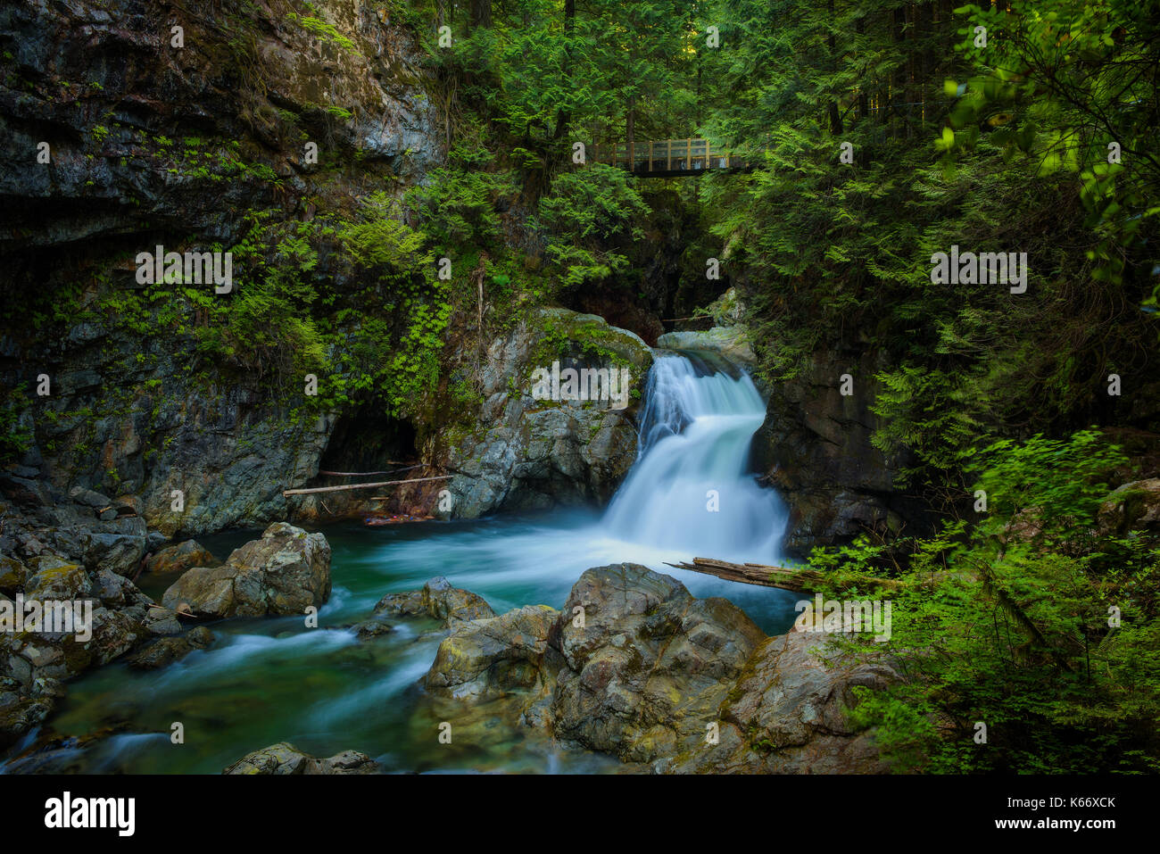 Twin Falls in Lynn Canyon Park mit Steg, North Vancouver, Kanada. Lange Belichtung. Stockfoto