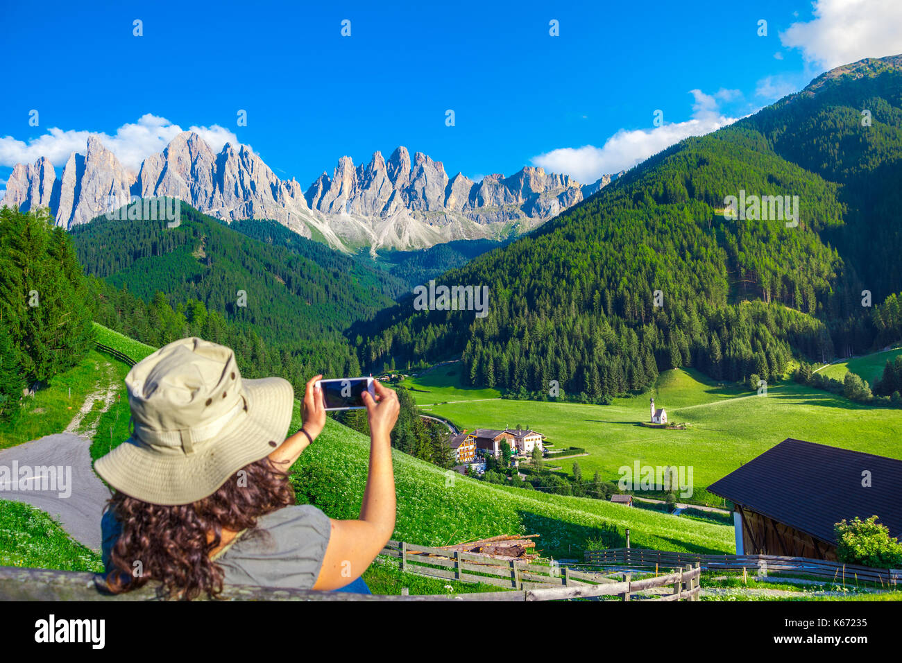 Frau genießen Sie den Blick auf die Dolomiten im Val di Funes Tal, Santa Maddalena, touristisches Dorf, Dolomiten, Italien, Europa Stockfoto