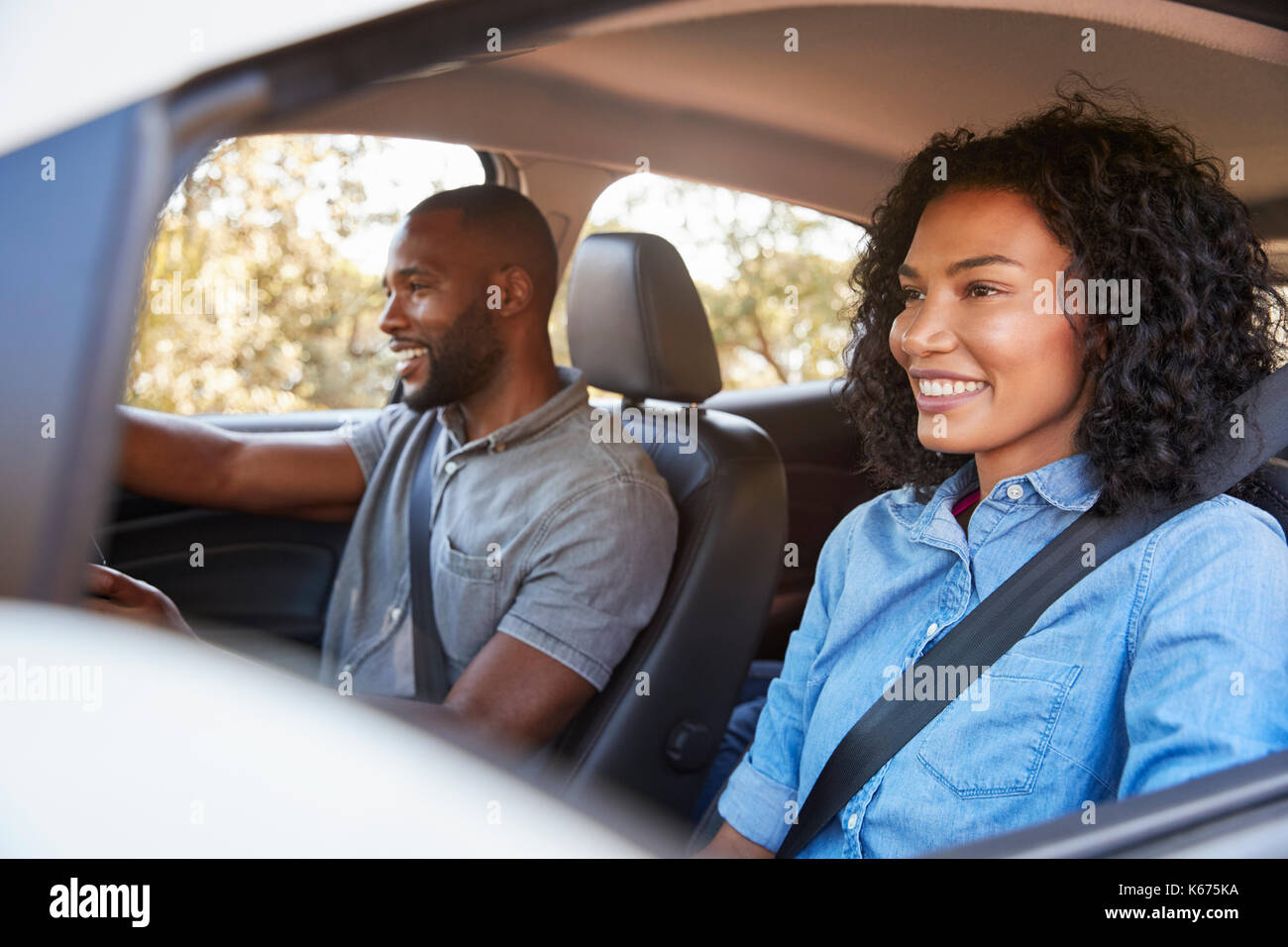 Junge schwarze Paar im Auto auf einem Road Trip look ahead lächelnd Stockfoto