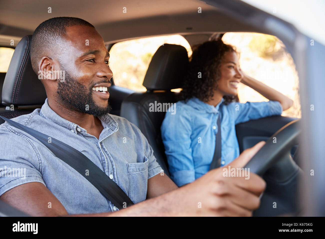 Junge schwarze Paar im Auto auf einem Road Trip look ahead lächelnd Stockfoto