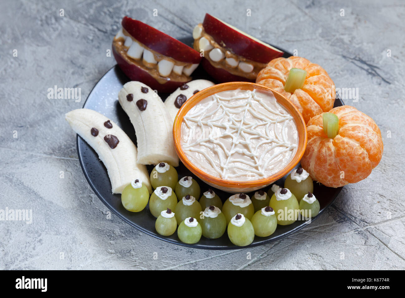 Gesunde Früchte Halloween Festlichkeiten. Banane Geister und Clementine  orange Kürbisse, Apple Monster Mounts und Spinnennetz Stockfotografie -  Alamy
