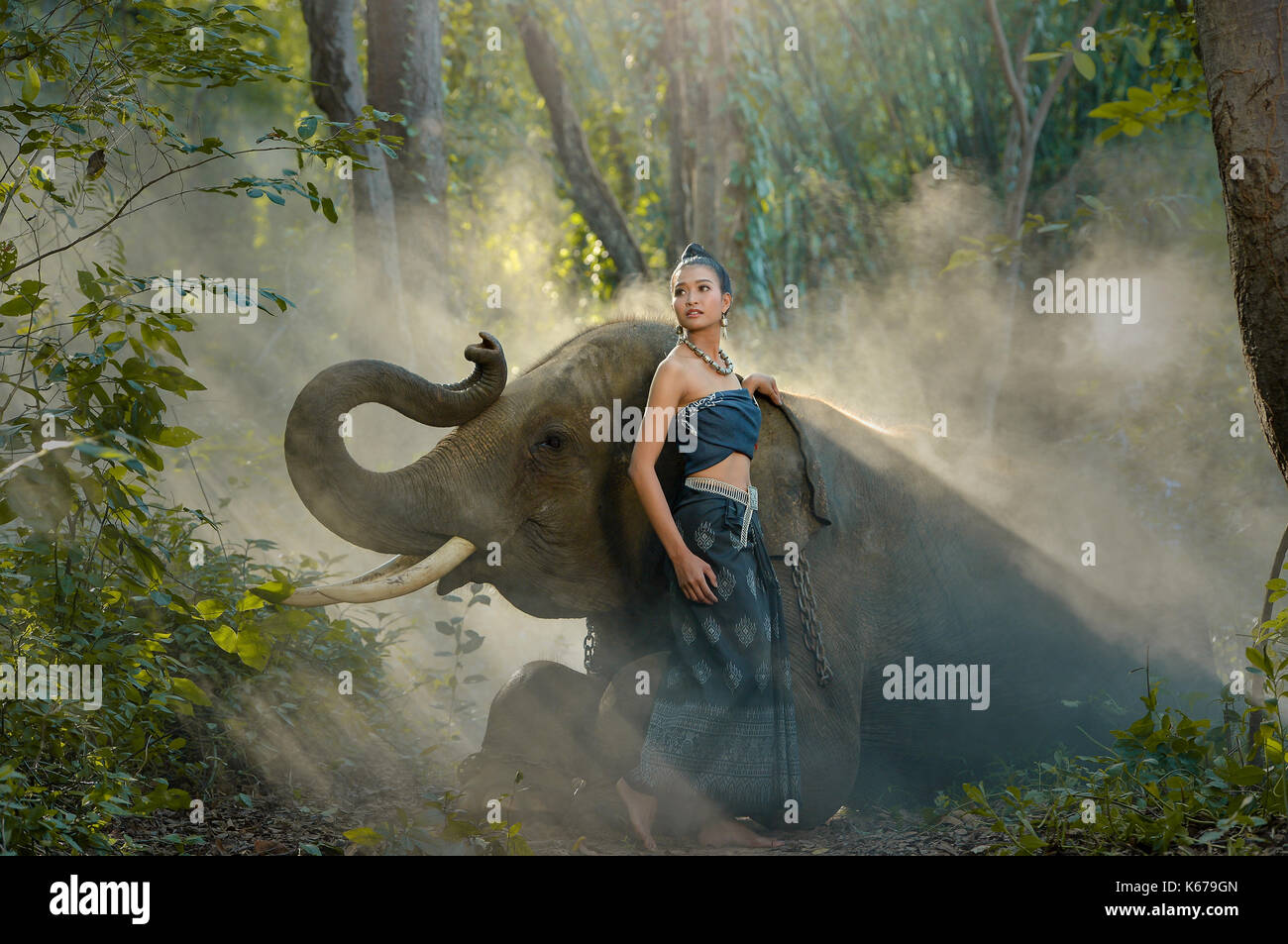 Frau, die traditionelle thailändische Bekleidung stehen im Wald mit einem Elefanten, Thailand Stockfoto
