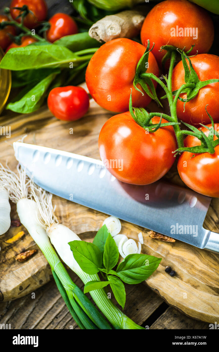 Frische Zutaten für die Küche in rustikalem Ambiente: Tomaten, Basilikum, Olivenöl, Knoblauch und Zwiebeln, Kohl, letttuce Stockfoto