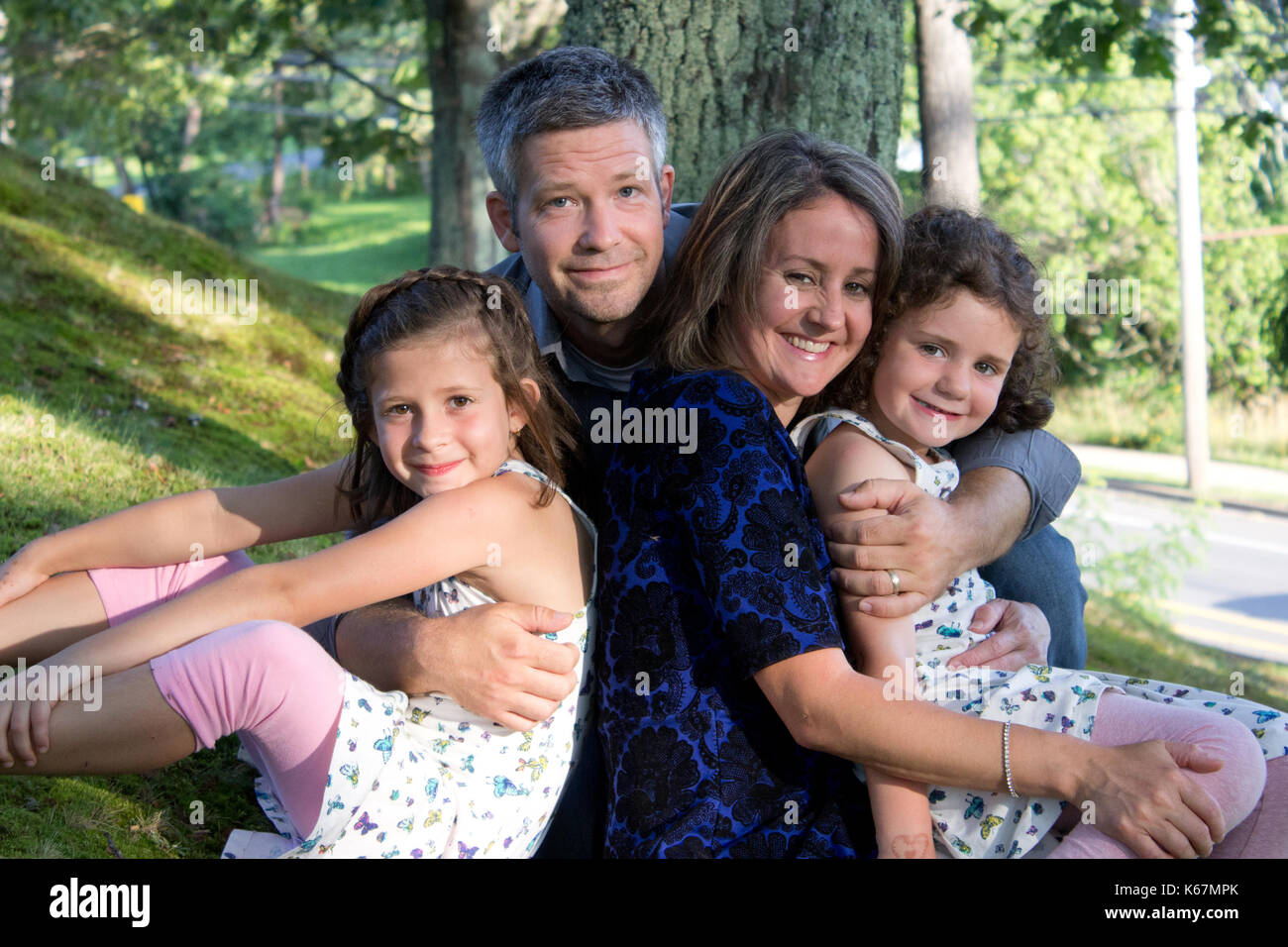 Vater, Mutter und ihre zwei schöne Töchter in einem Porträt außerhalb Stockfoto