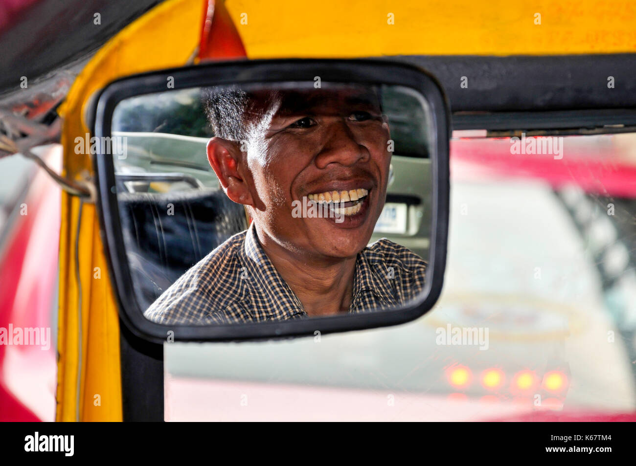 Lächelnd Tuk-tuk Fahrer in Spiegel, Samphanthawong District, Bangkok, Thailand Stockfoto