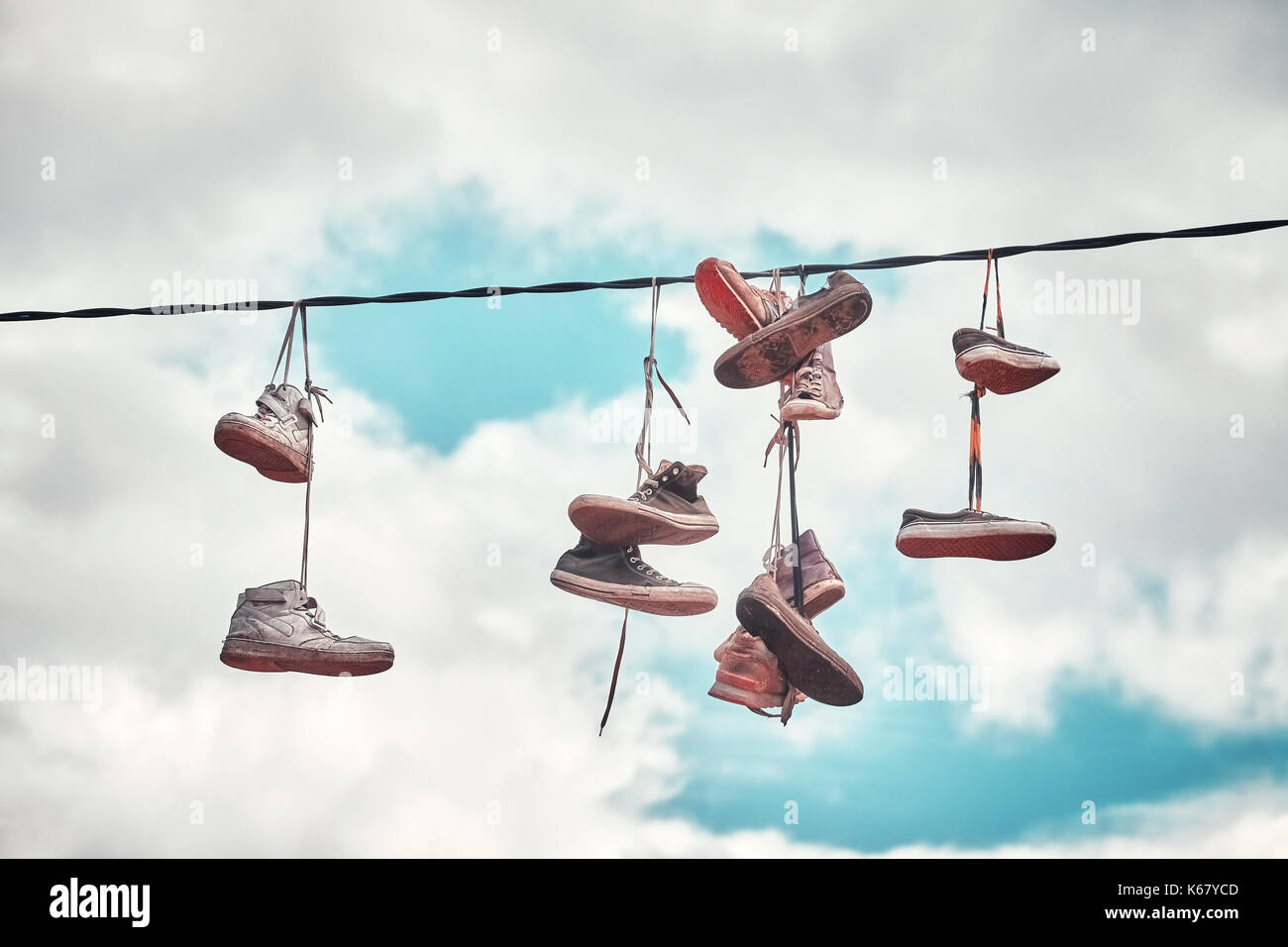 Vintage stilisierte Bild vom alten schmutzigen Schuhe hängen auf Draht. Stockfoto