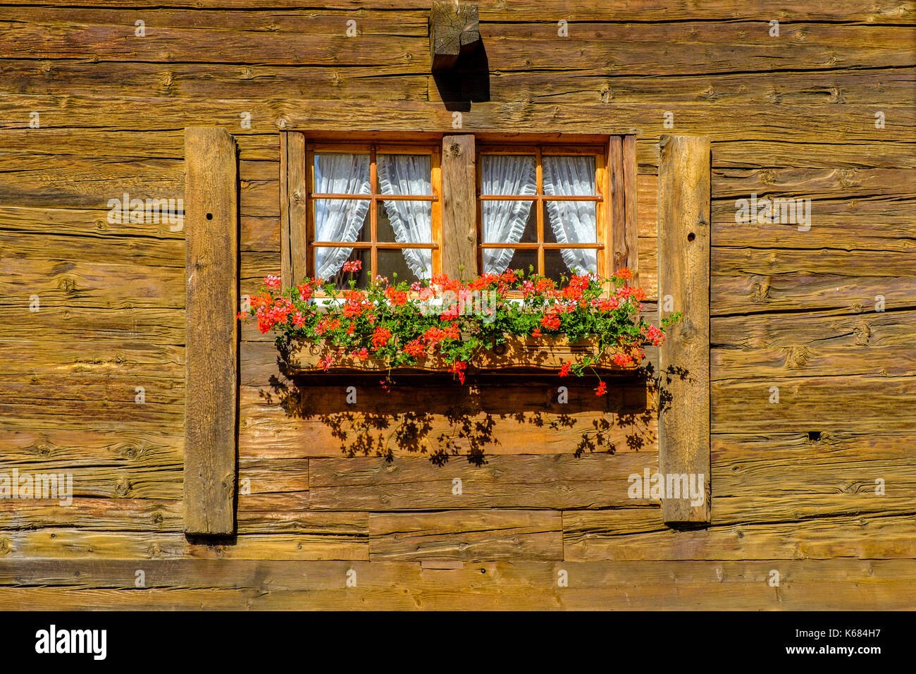 Das kleine Fenster von einem alten Bauernhaus, mit bunten Blumen geschmückt  Stockfotografie - Alamy