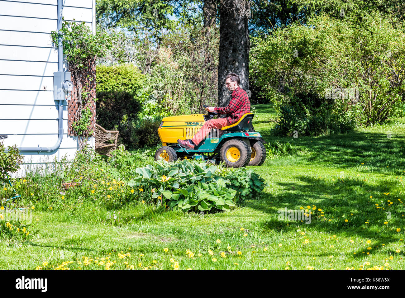 Ile d'Orleans, Kanada - 1. Juni 2017: Mann, Mann auf Yard-man Rasentraktor Traktor in Quebec Apple Orchard Farm Landschaftsgestaltung, Mähen seinen Garten, Hinterhof Stockfoto