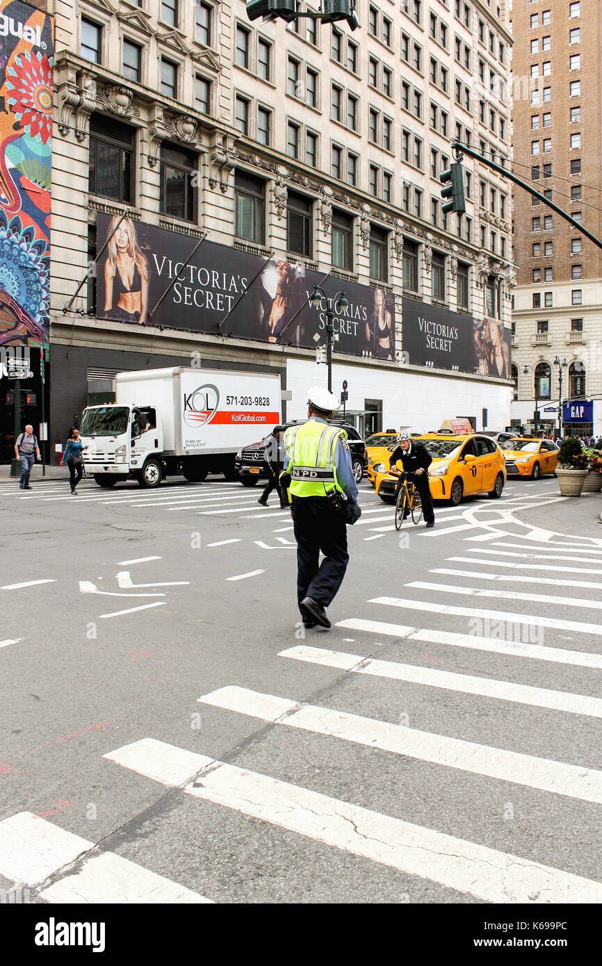 New York, USA - September 2016: NYPD traffic officer Regie Fußgänger und den Verkehr an der Kreuzung von Sixth Avenue und West 35th Street Stockfoto