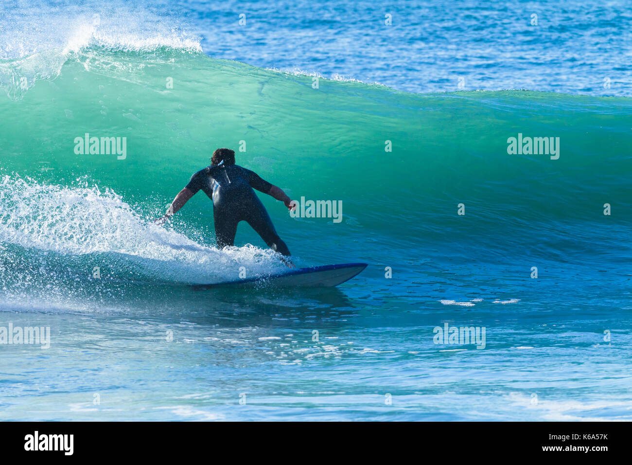 Unbekannter Surfer surfen Rides Ocean Wave Aktion Foto Stockfoto