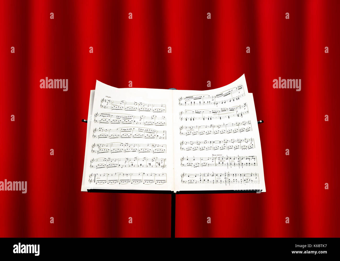 Notenständer mit einer Partitur vor einem roten Vorhang Stockfoto