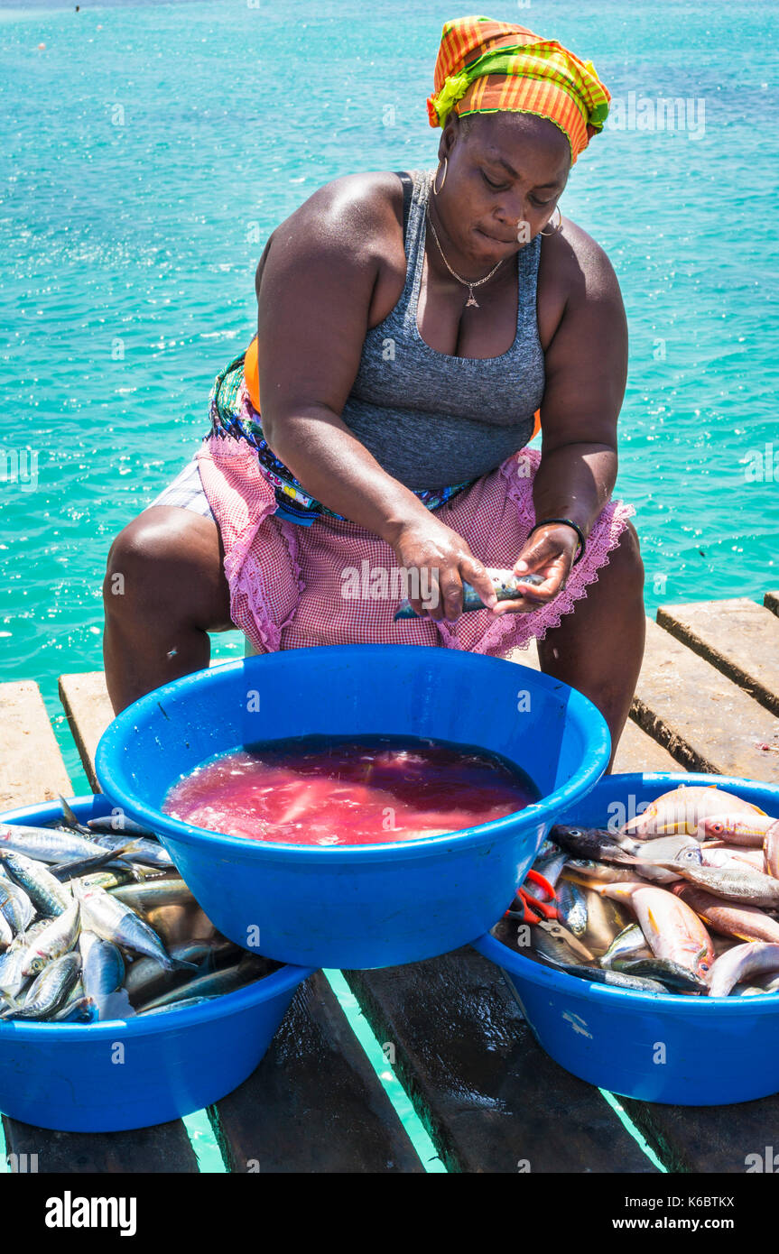 Kap VERDE-SAL lokale Frau Skalierung und einen frisch gefangenen Fisch auf dem hölzernen Pier in Santa Maria Insel Sal Kapverden Afrika ausnehmen Stockfoto