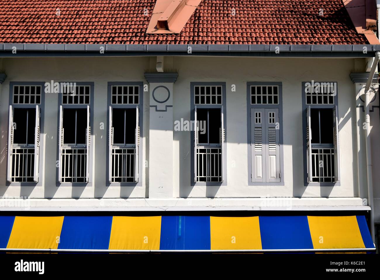 Traditionelle Singapur shop Haus außen mit grauen hölzerne Lamellenfensterläden und gestreiften Markise in der historischen Duxton Bereich. Stockfoto