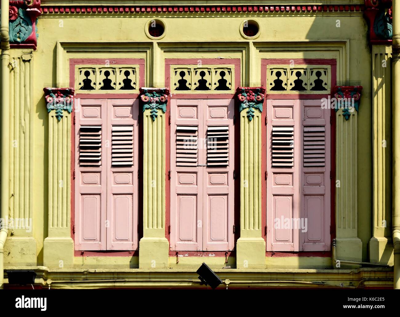 Traditionelle Singapur shop Haus außen mit Rosa hölzerne Lamellenfensterläden, gelbe Fassade und verzierten Säulen im historischen Duxton Bereich. Stockfoto