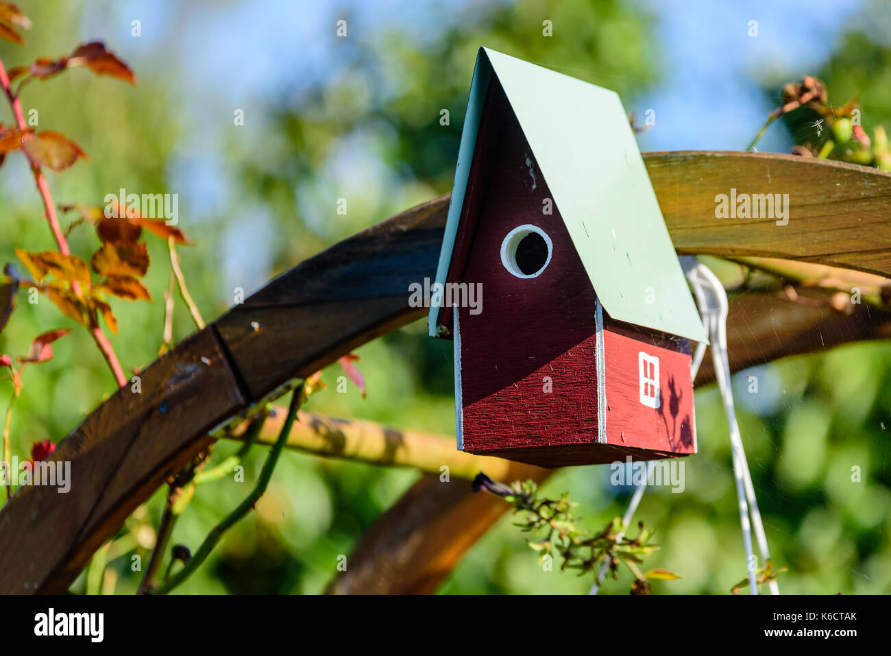 Hausgemachte rote und weiße Nistkasten oder Vogelhaus. Stockfoto