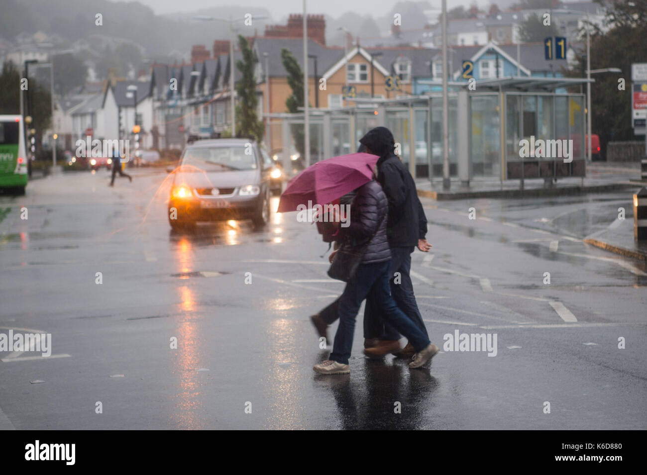 Aberystwyth Wales UK, Dienstag, 12. Sep 2017 UK Wetter: Sturm Aileen bringt die sintflutartigen Regenfälle Fußgänger zu genießen, wie sie in Aberystwyth. Mehr als die Hälfte Durchschnitt in diesem Monat Regen vorausgesagt wird im Norden und Westen von Großbritannien in den nächsten Stunden zu gießen. Photo Credit: Keith Morris/Alamy leben Nachrichten Stockfoto