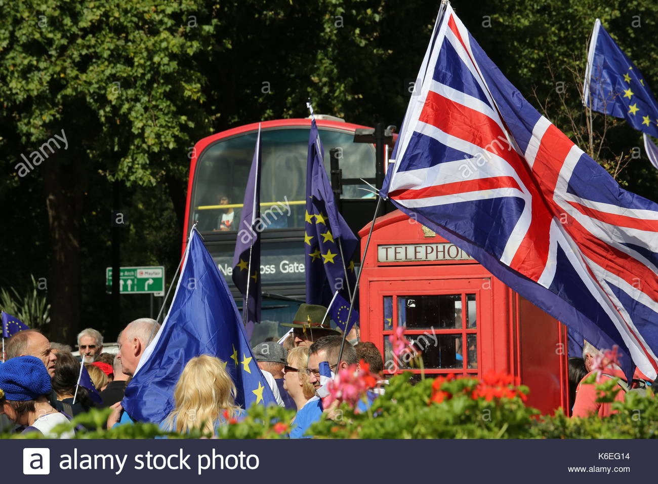 Eine rote Telefonzelle durch EU- und UK-Flags in der Nähe von Hyde Park als red London Bus vorbeifährt umgeben. Credit: reallifephotos/Alamy Stockfoto