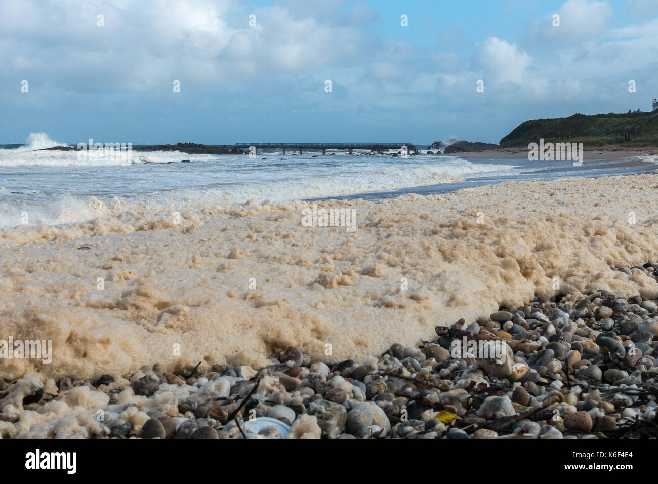 Bewölktem Himmel, wilde Küstenlandschaft und das Meer Schaum oder Gischt, Waschen der Kiesstrand in Carrickmore Rd, BT54, Ballycastle, Nordirland, Großbritannien Stockfoto