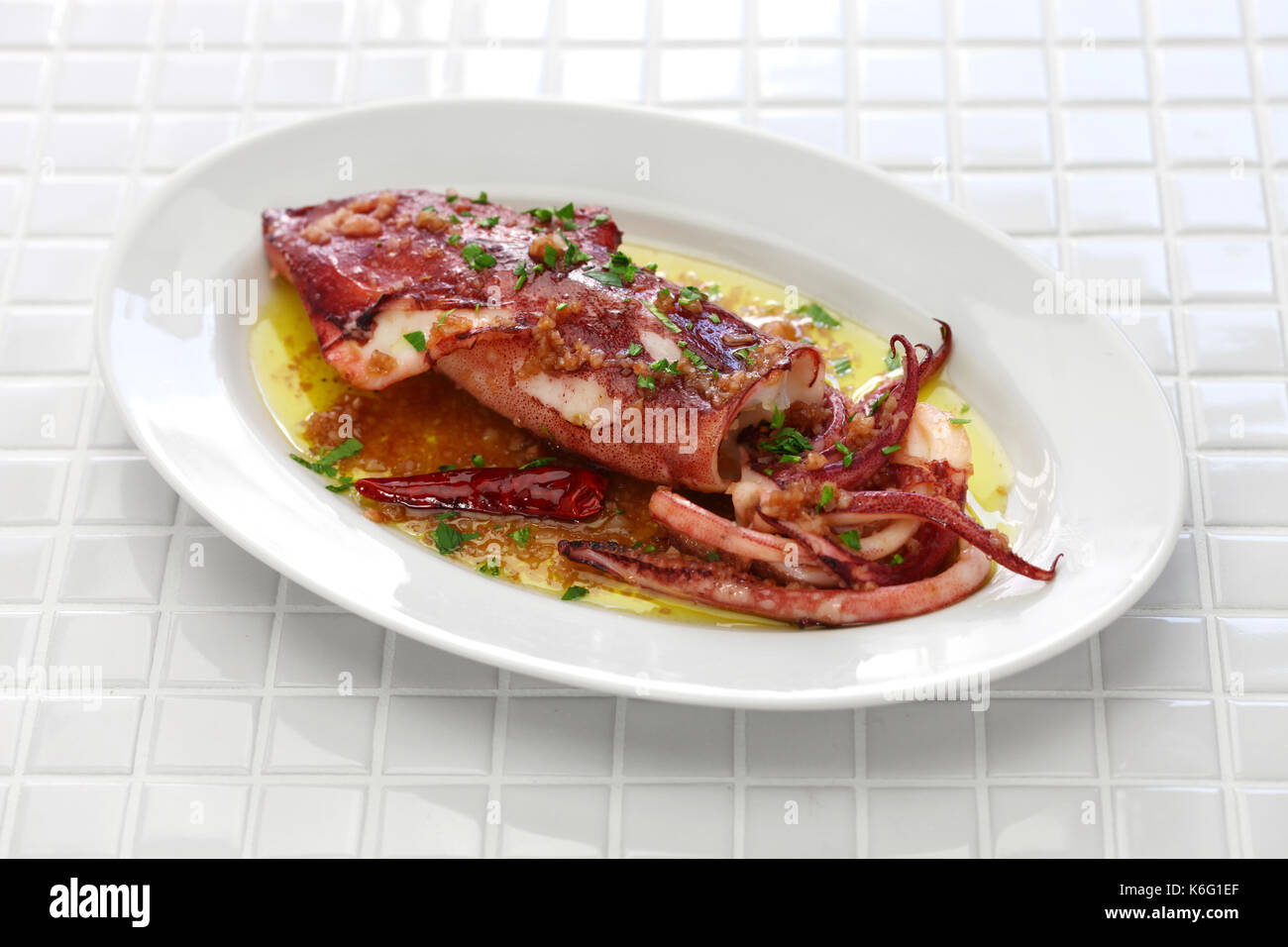 Sautierte Calamari mit Petersilie und Knoblauch, spanische Tapas essen, calamar a la plancha Stockfoto