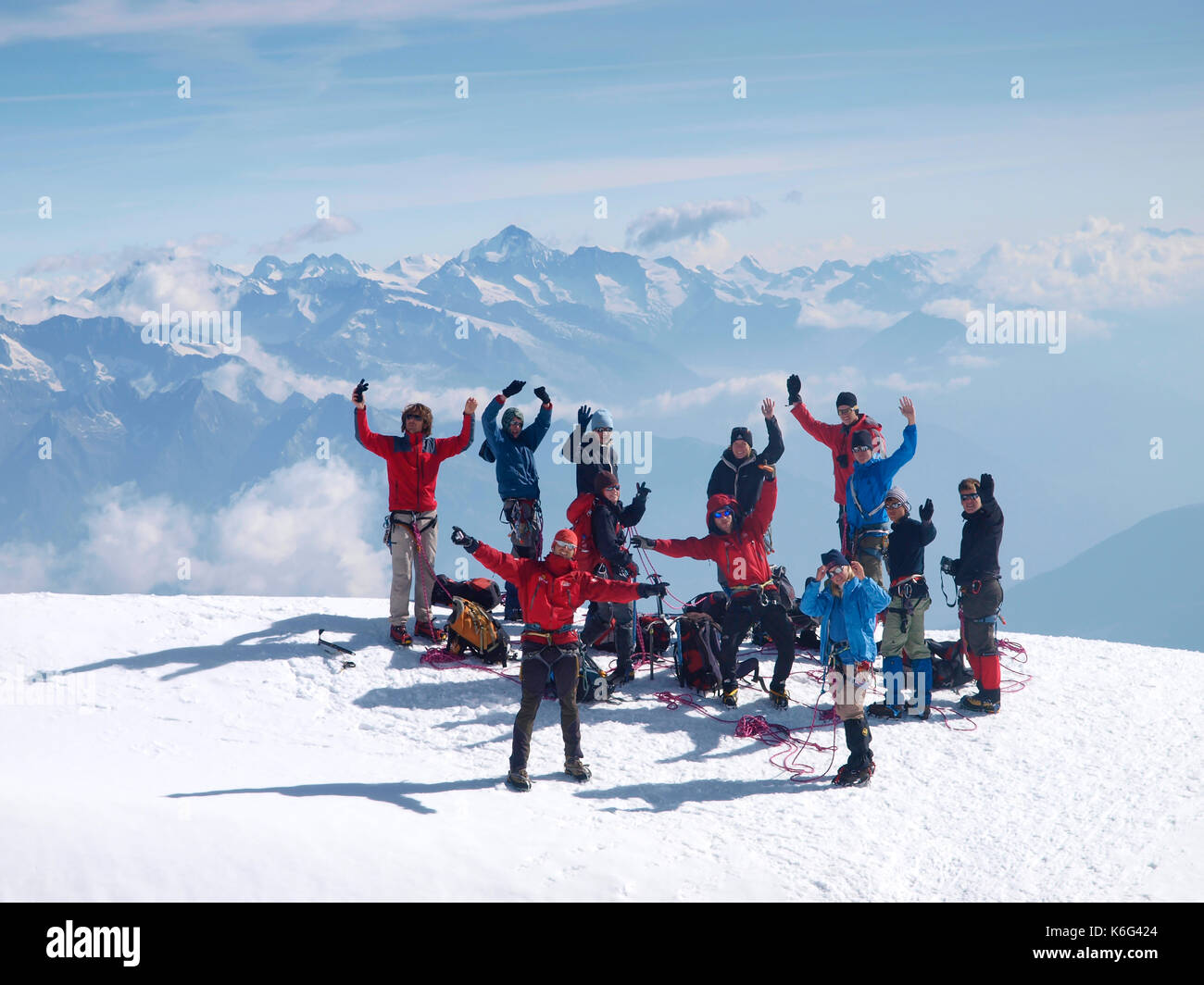 Gruppe von Jugendlichen winken beim Stehen auf Berggipfel, Zermatt, Wallis, Schweiz Stockfoto