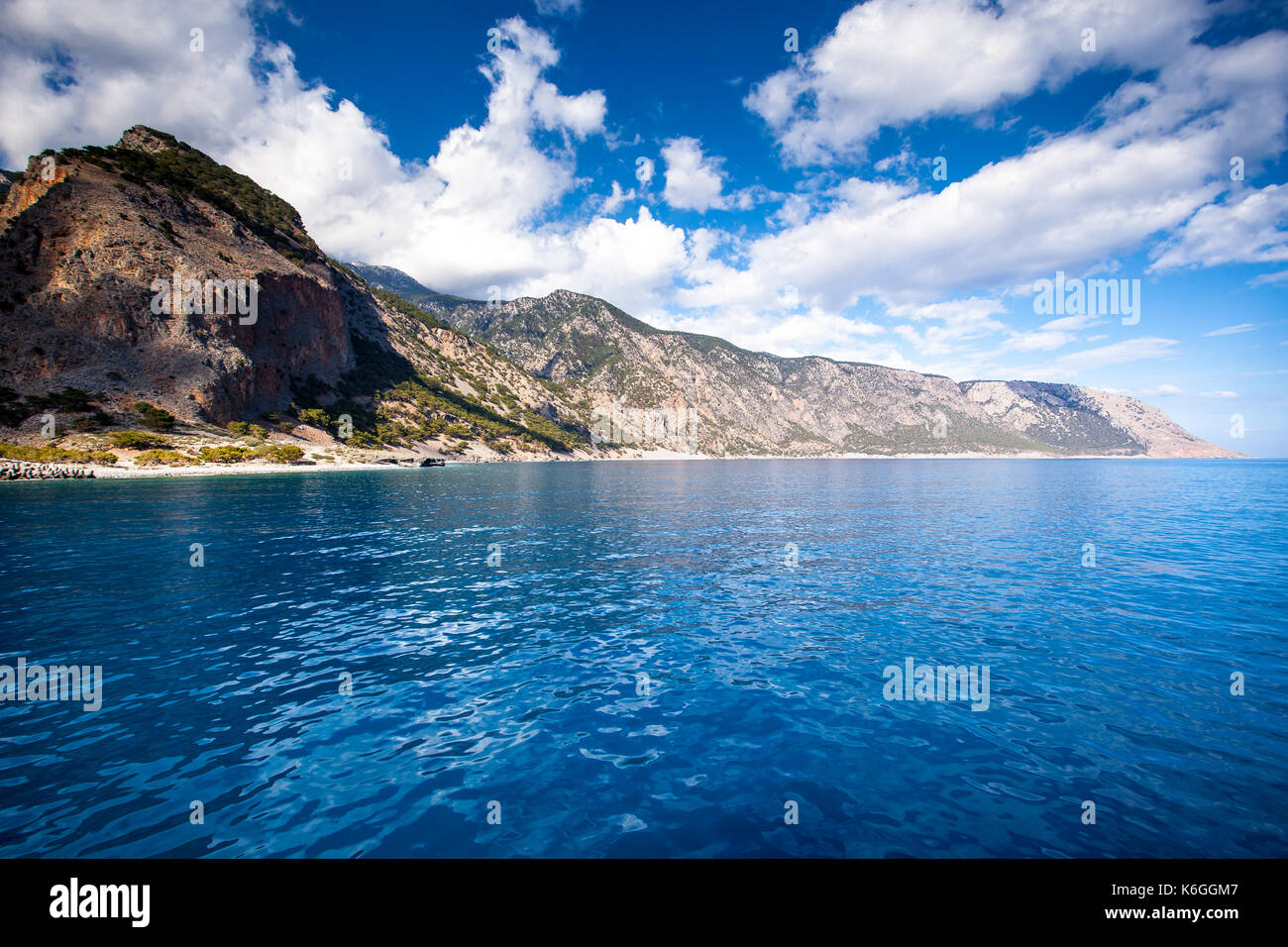 Panoramablick auf Kreta (Griechenland) Bergen des Libyschen Meer. das Fahren mit einem Boot entlang von Samaria Schlucht in Richtung Loutro Dorf. Im Hintergrund vill Stockfoto